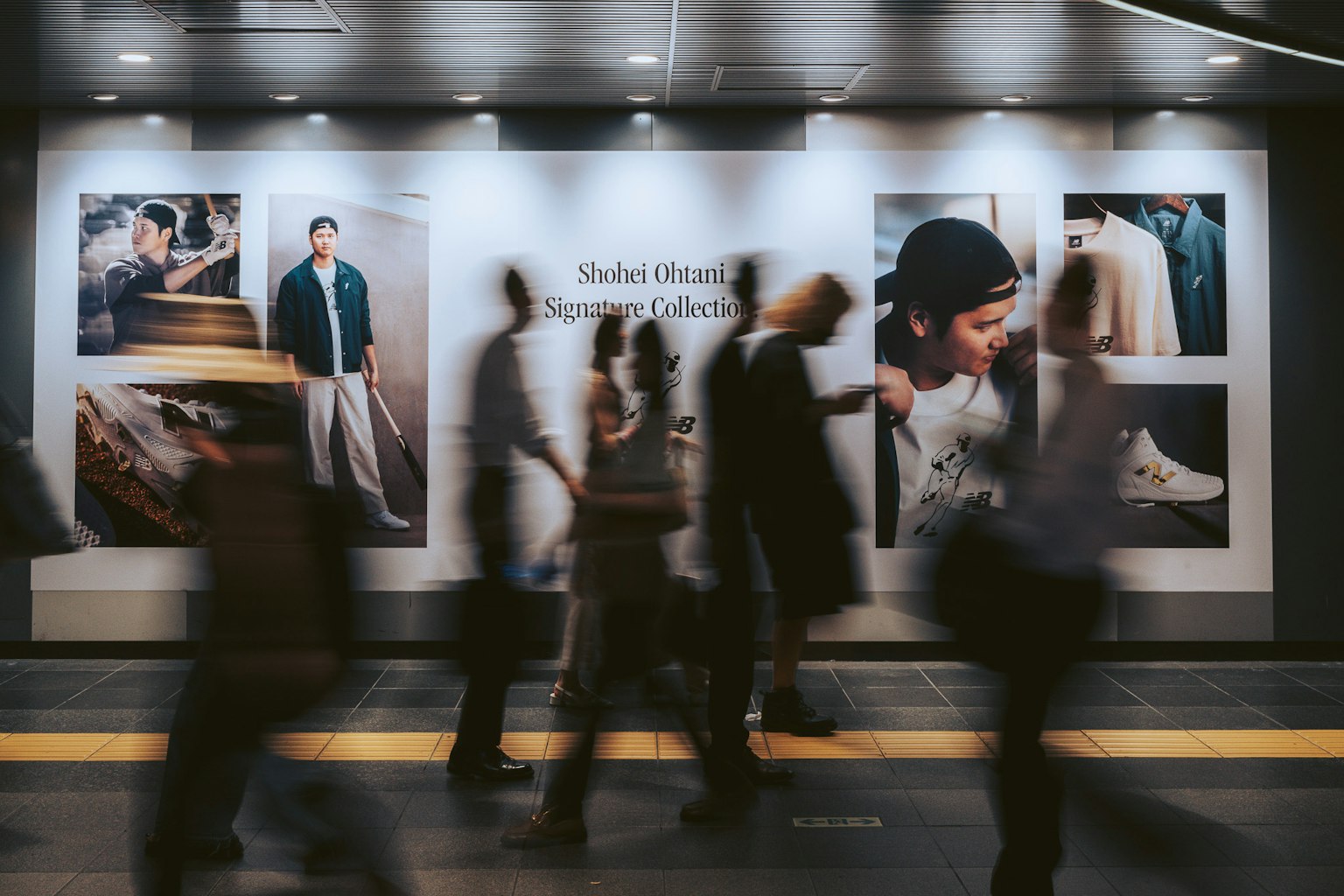 Pemandangan stasiun yang sibuk dengan pejalan kaki kabur melewati iklan mode