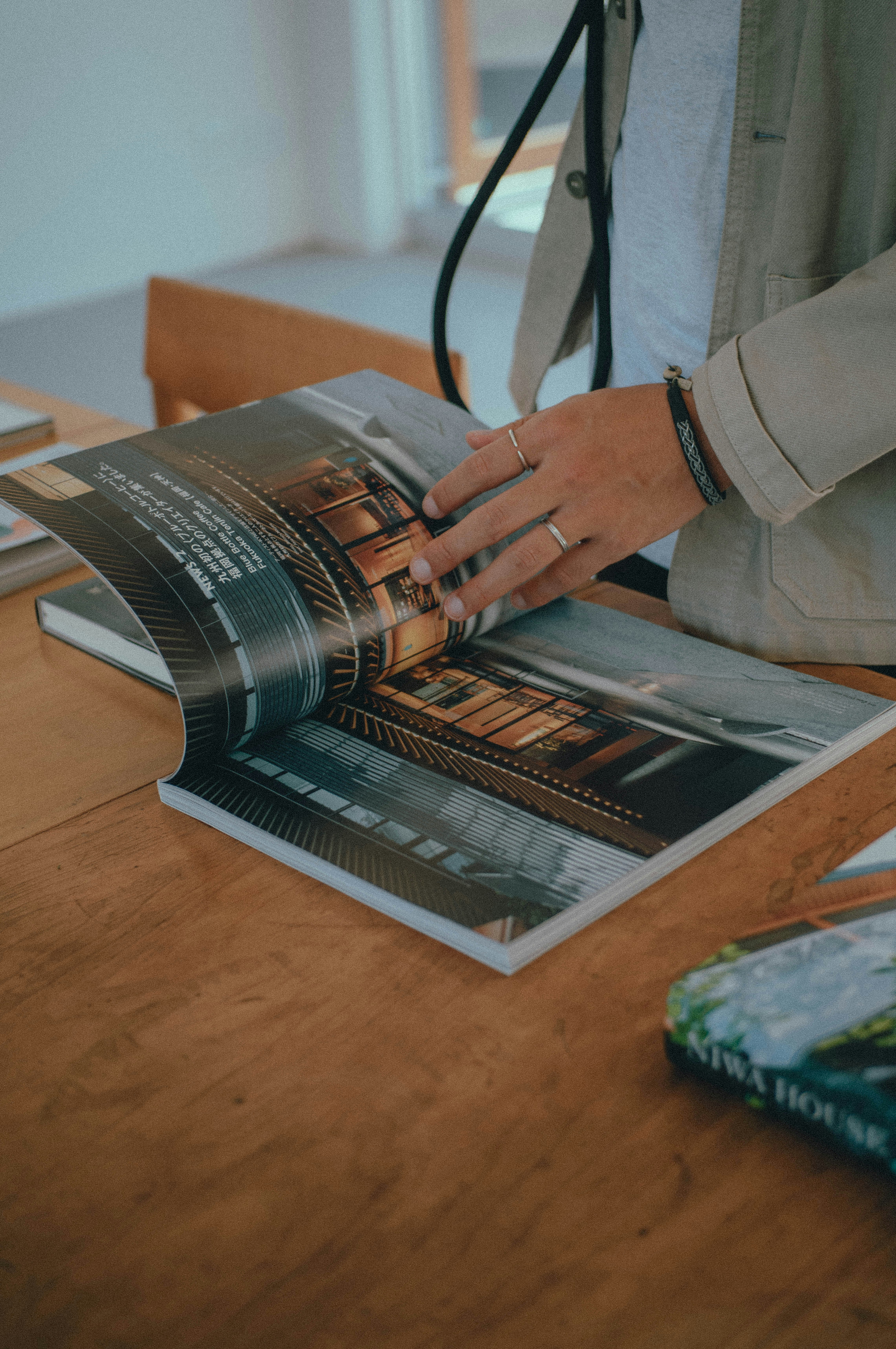 hands flipping through a magazine on a table