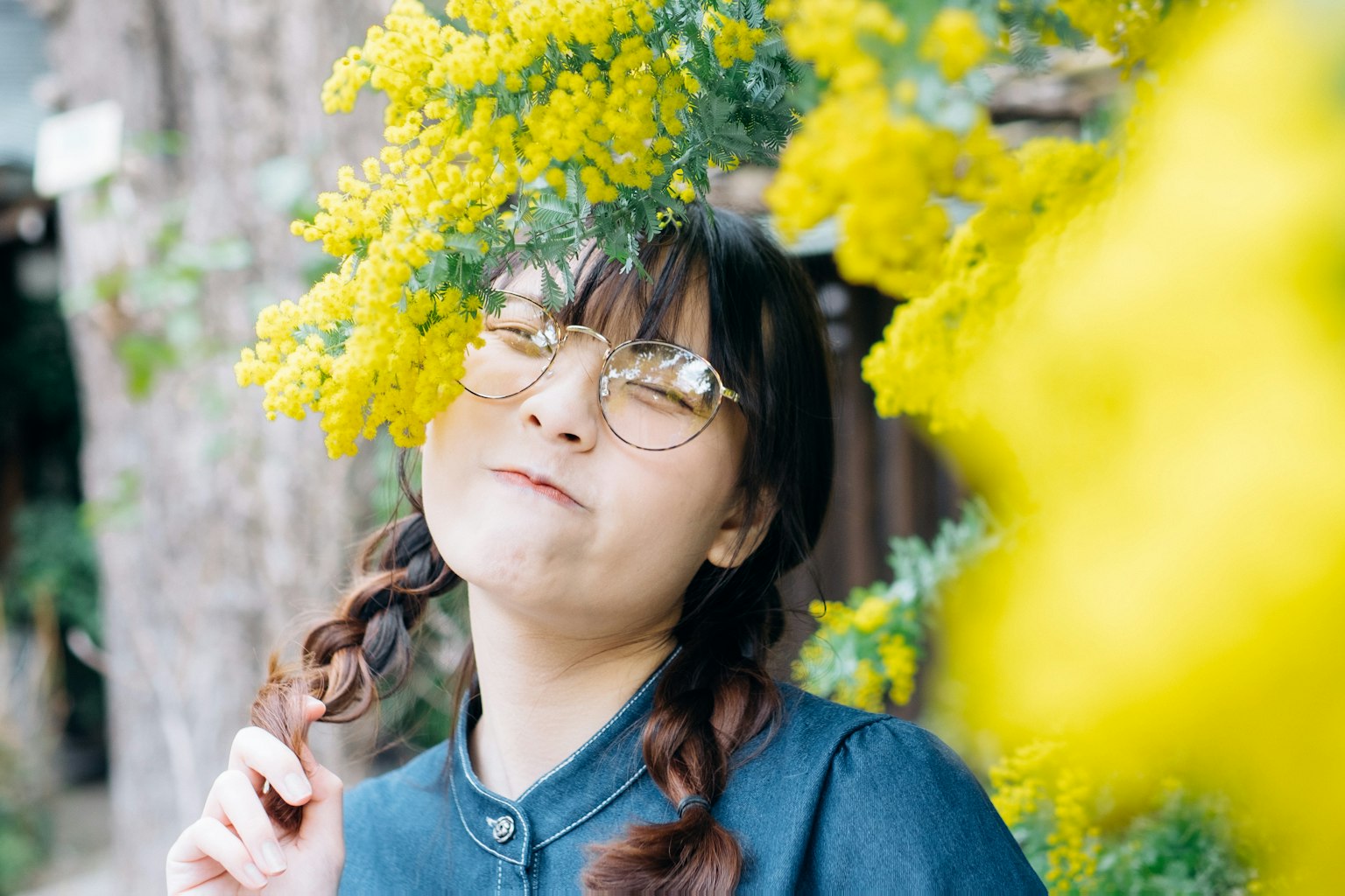 一個戴眼鏡的女孩微笑著被黃色花朵包圍