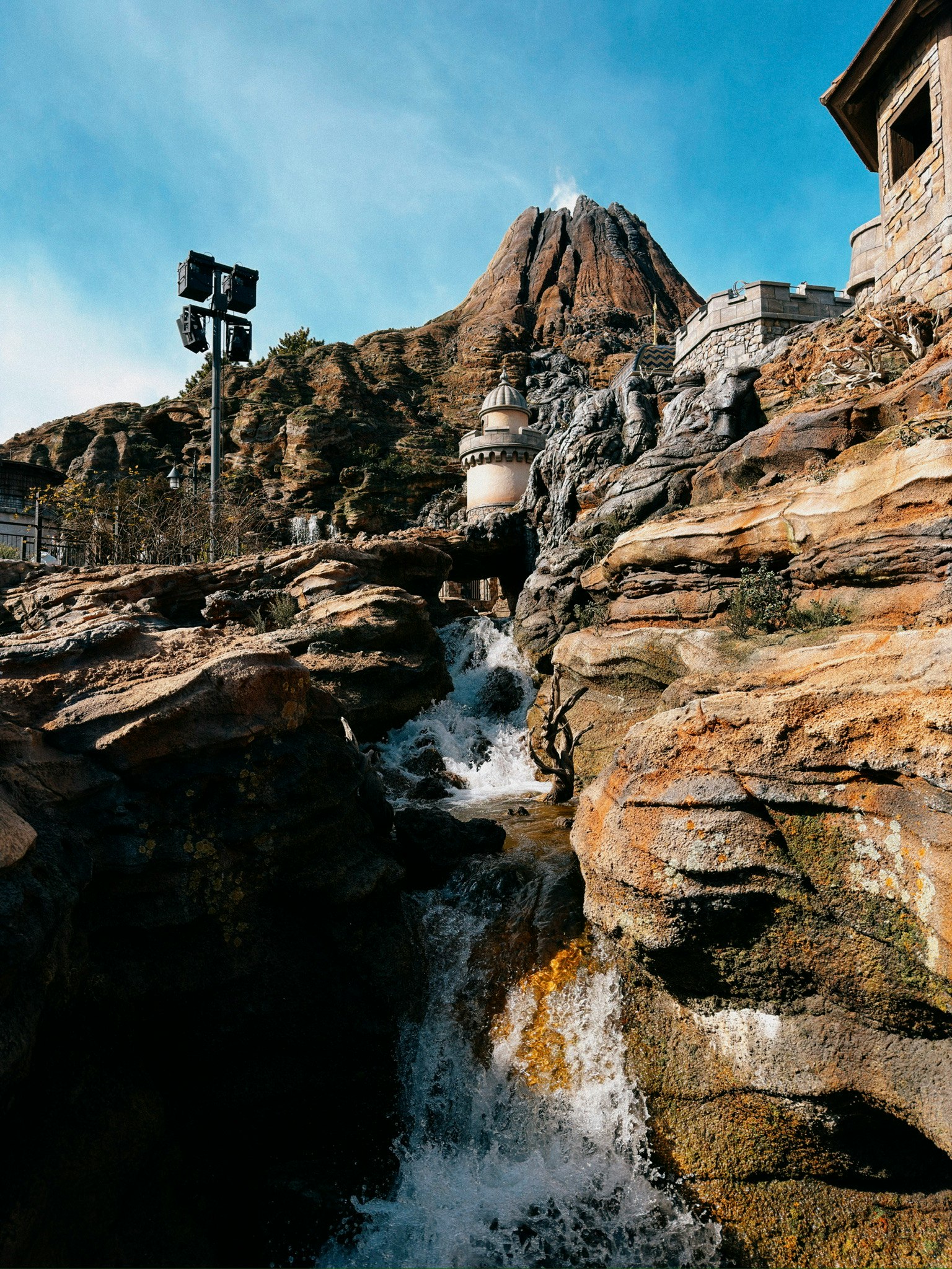 Ein Wasserfall über Felsen mit einem Berg im Hintergrund