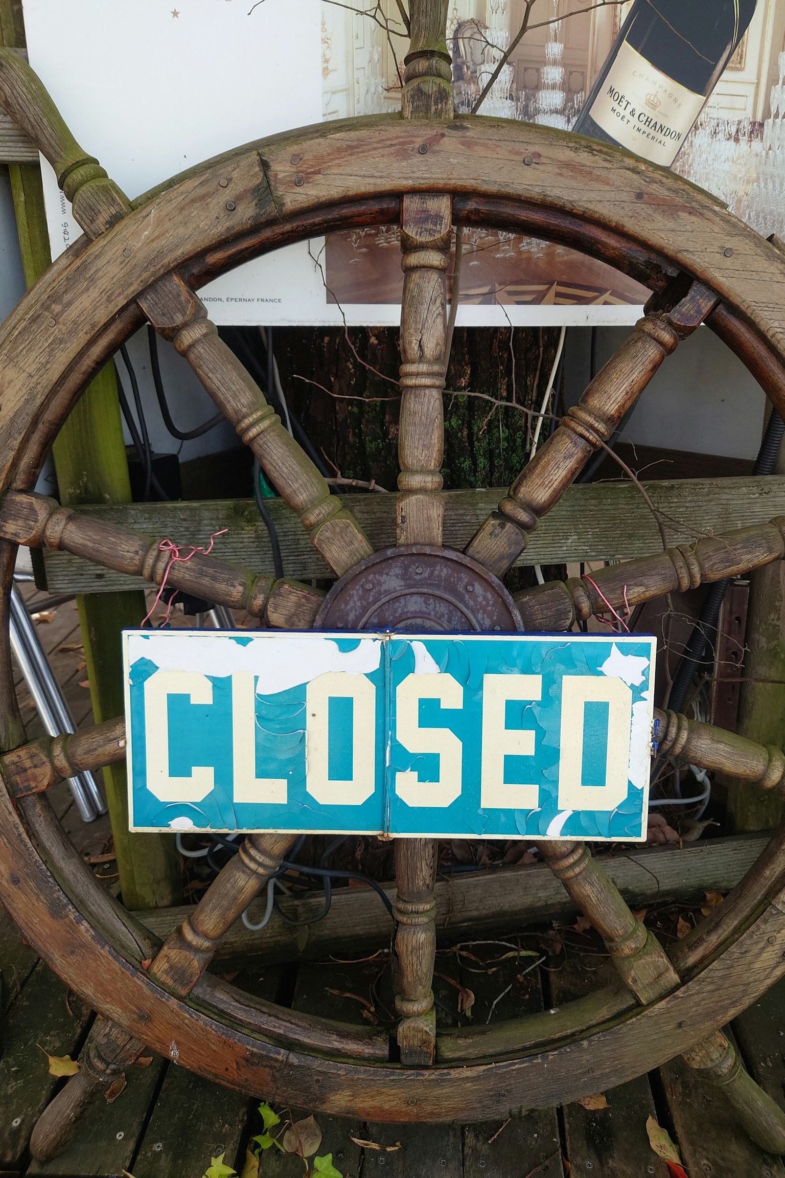 Immagine di una vecchia ruota di nave con un cartello blu CLOSED