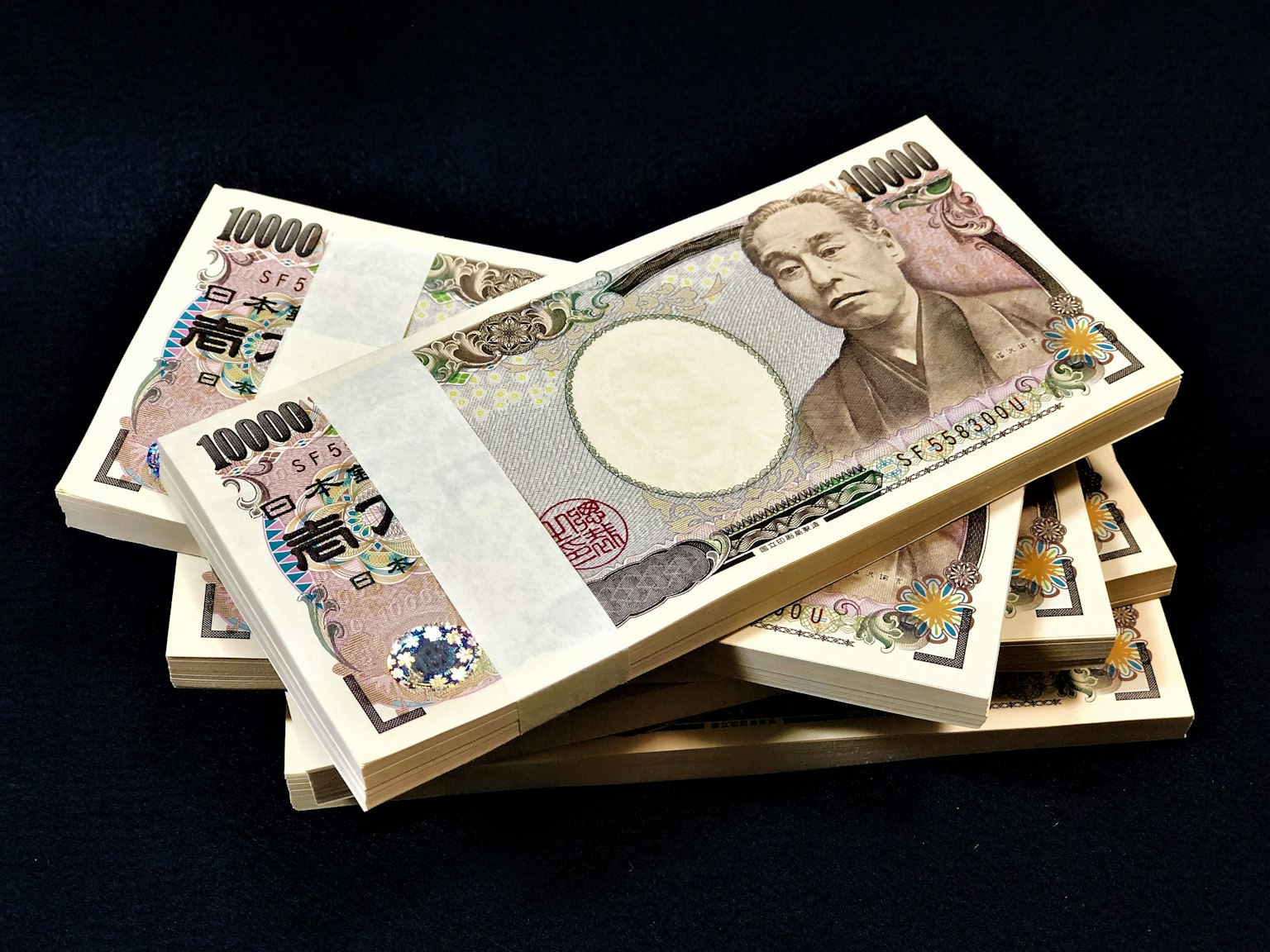 Mazzo di banconote da 10.000 yen giapponesi su sfondo scuro