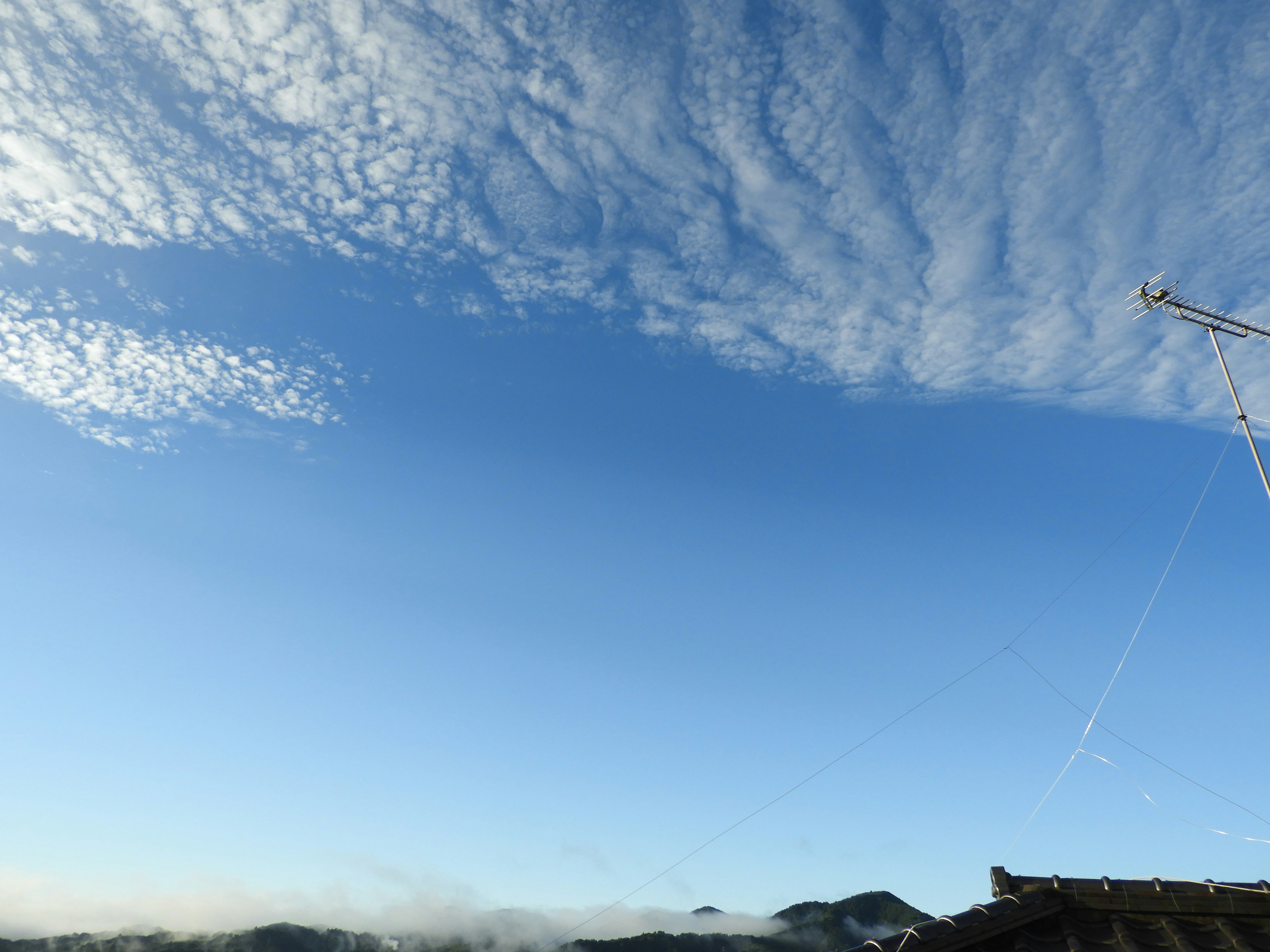 lignes électriques s’étendant dans un ciel bleu avec des nuages