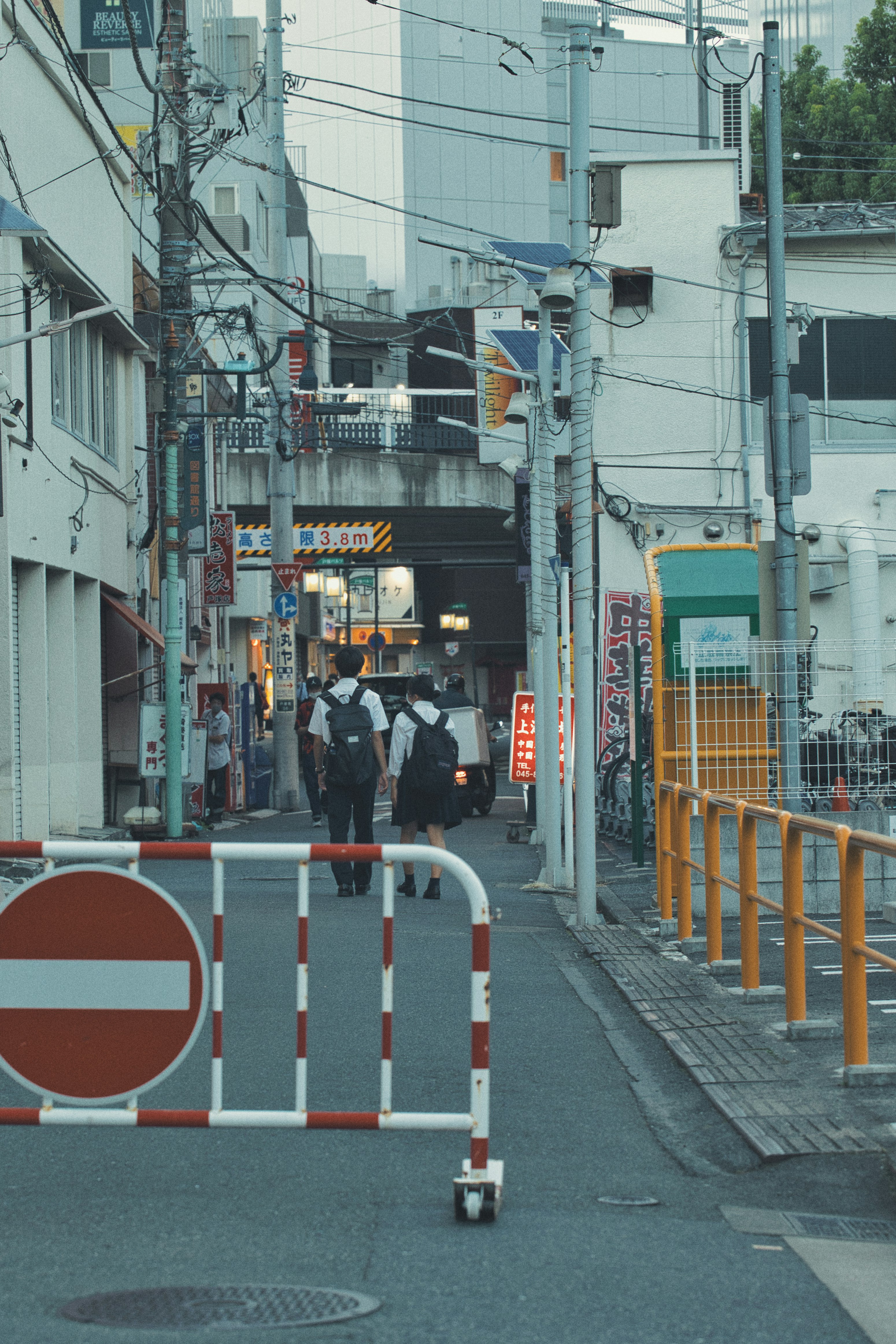 路地に並ぶ電線と看板のある商店街の通り