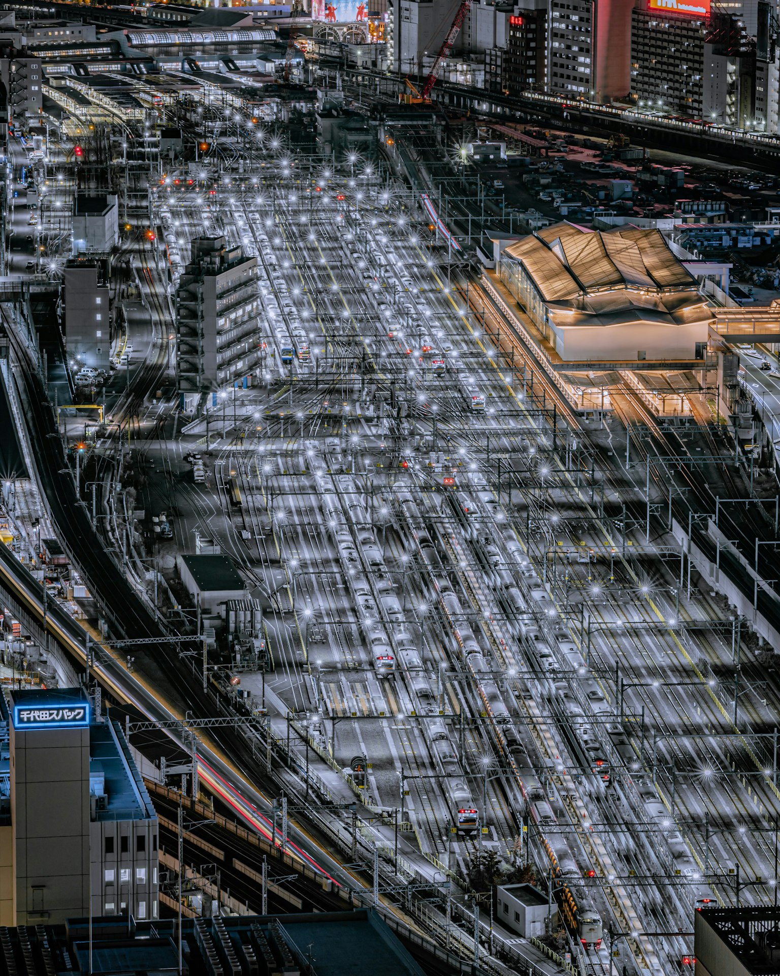 Vue aérienne d'une ville la nuit avec des voies de train illuminées