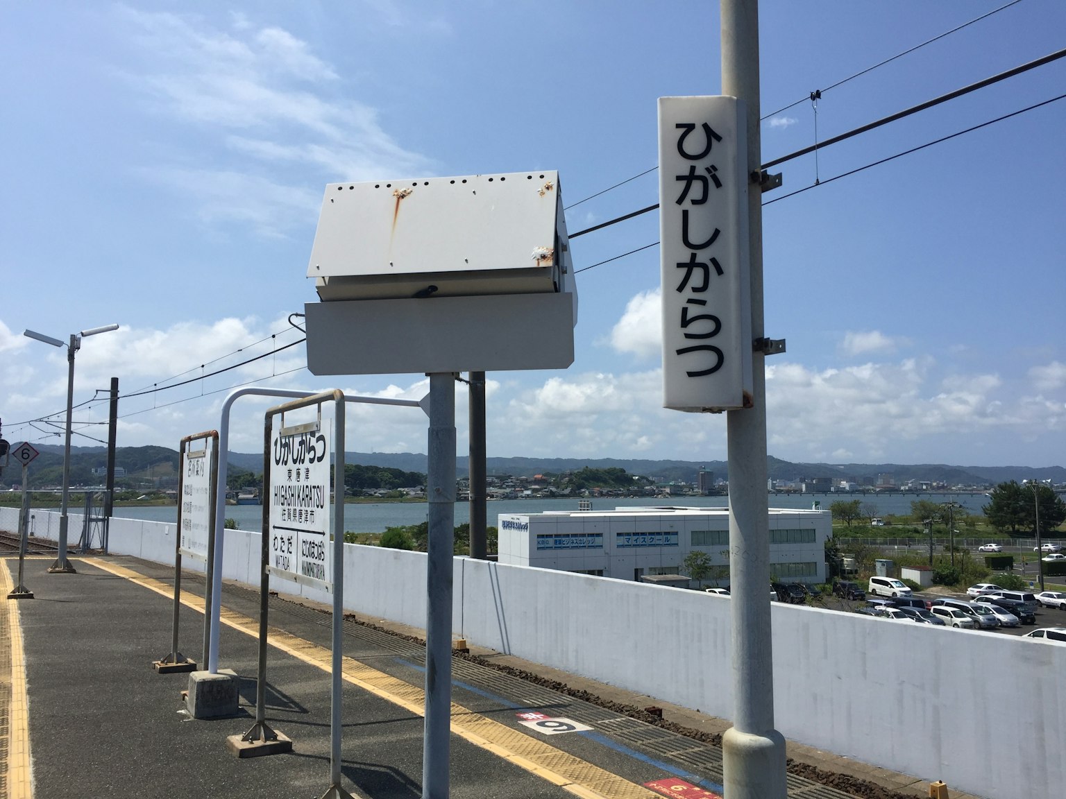 Plateforme de gare avec des panneaux et une vue sous un ciel bleu