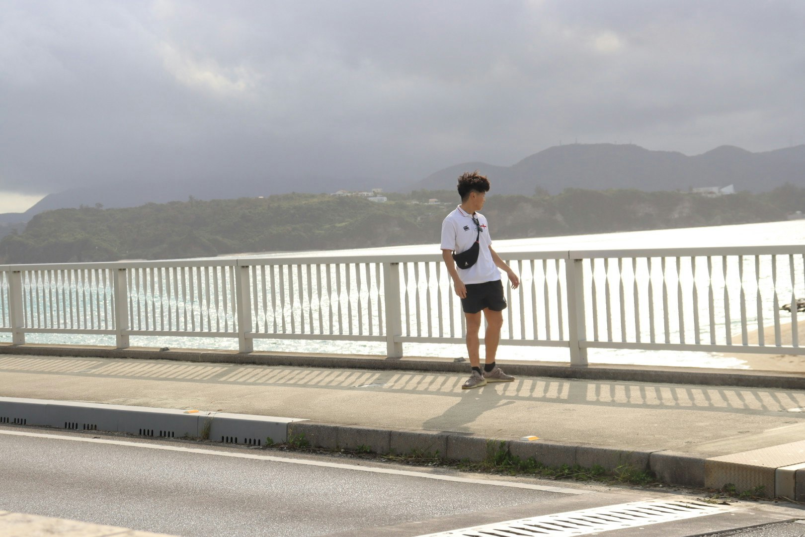 沖縄の海を望む展望デッキで歩く旅行者