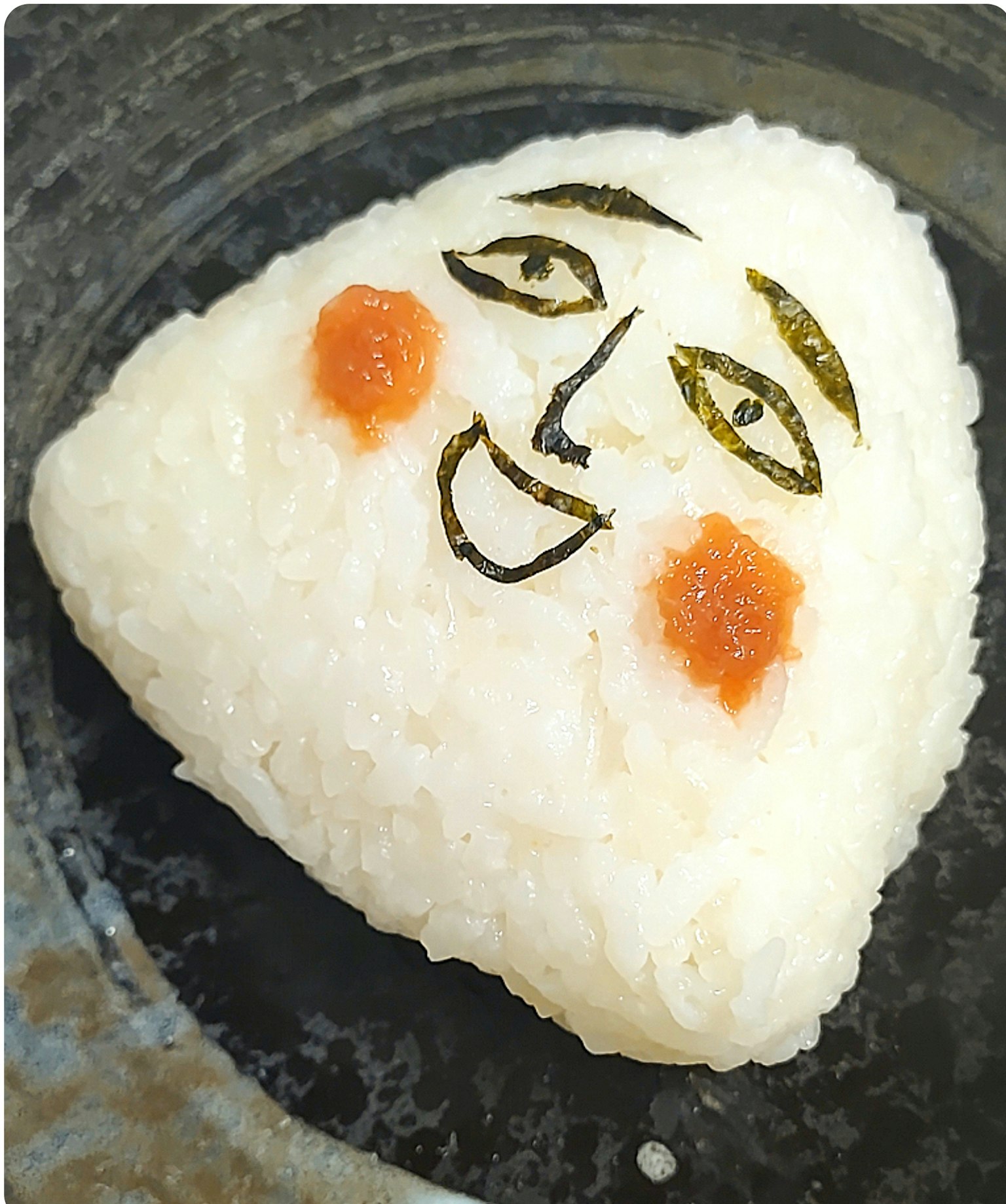Image d'une boule de riz avec un visage dessiné
