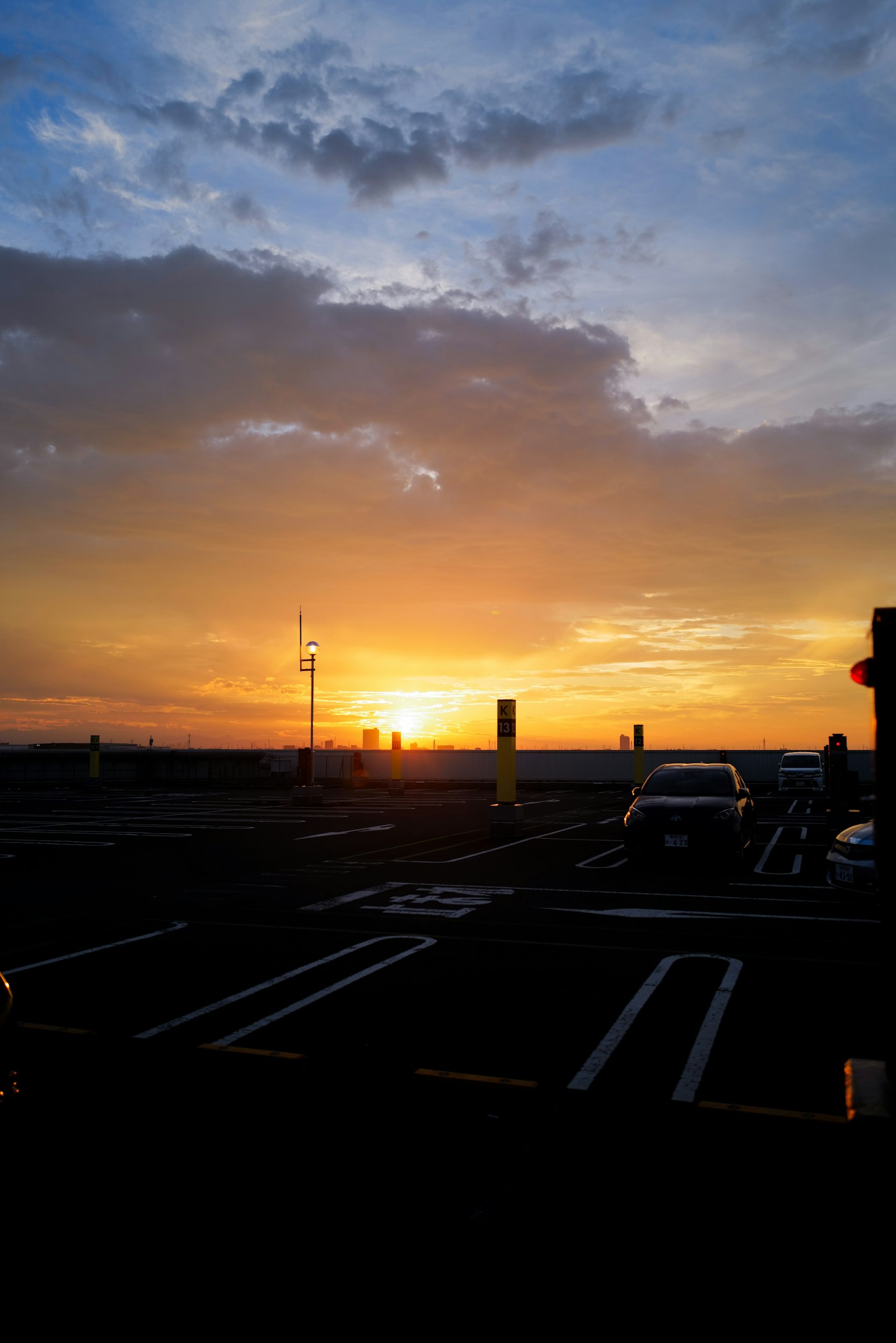 Schöner Sonnenuntergangshimmel mit lebhaften Farben von einem Parkplatz aus sichtbar