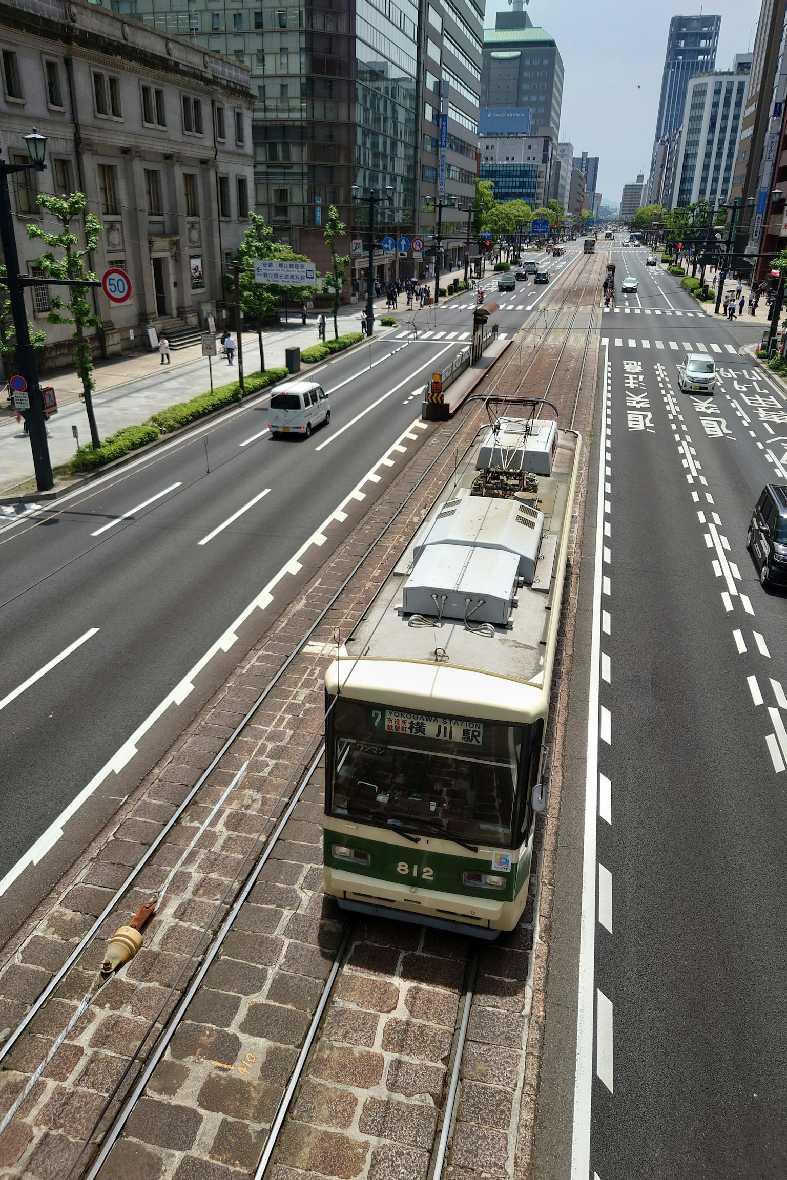 Straßenbahn, die auf einer Stadtstraße mit umliegenden Gebäuden fährt