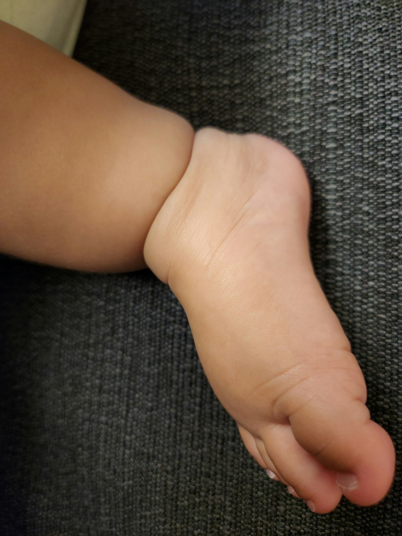 Pied de bébé reposant sur un canapé