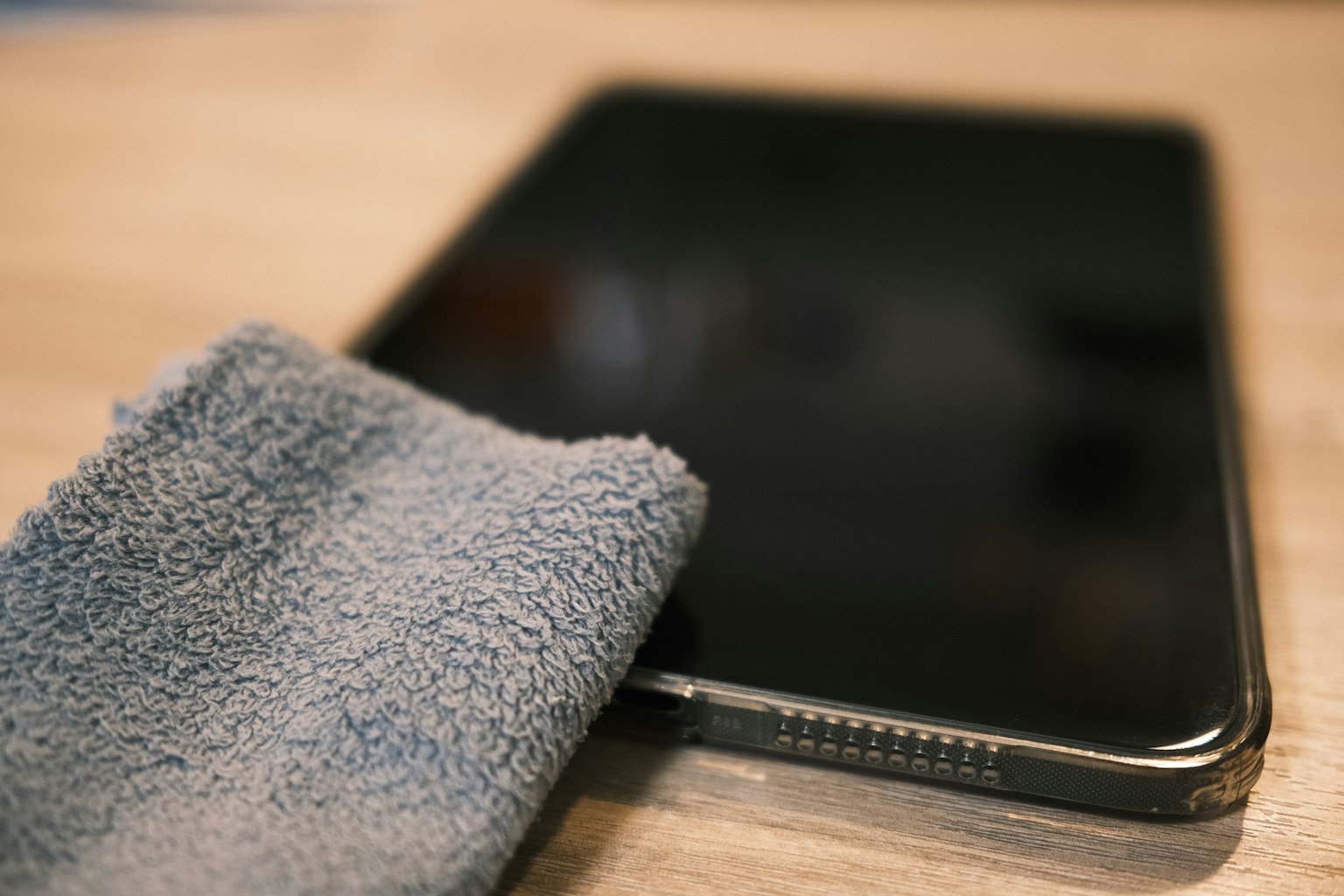 Schwarzes Bildschirm-Tablet mit einem blauen Reinigungstuch