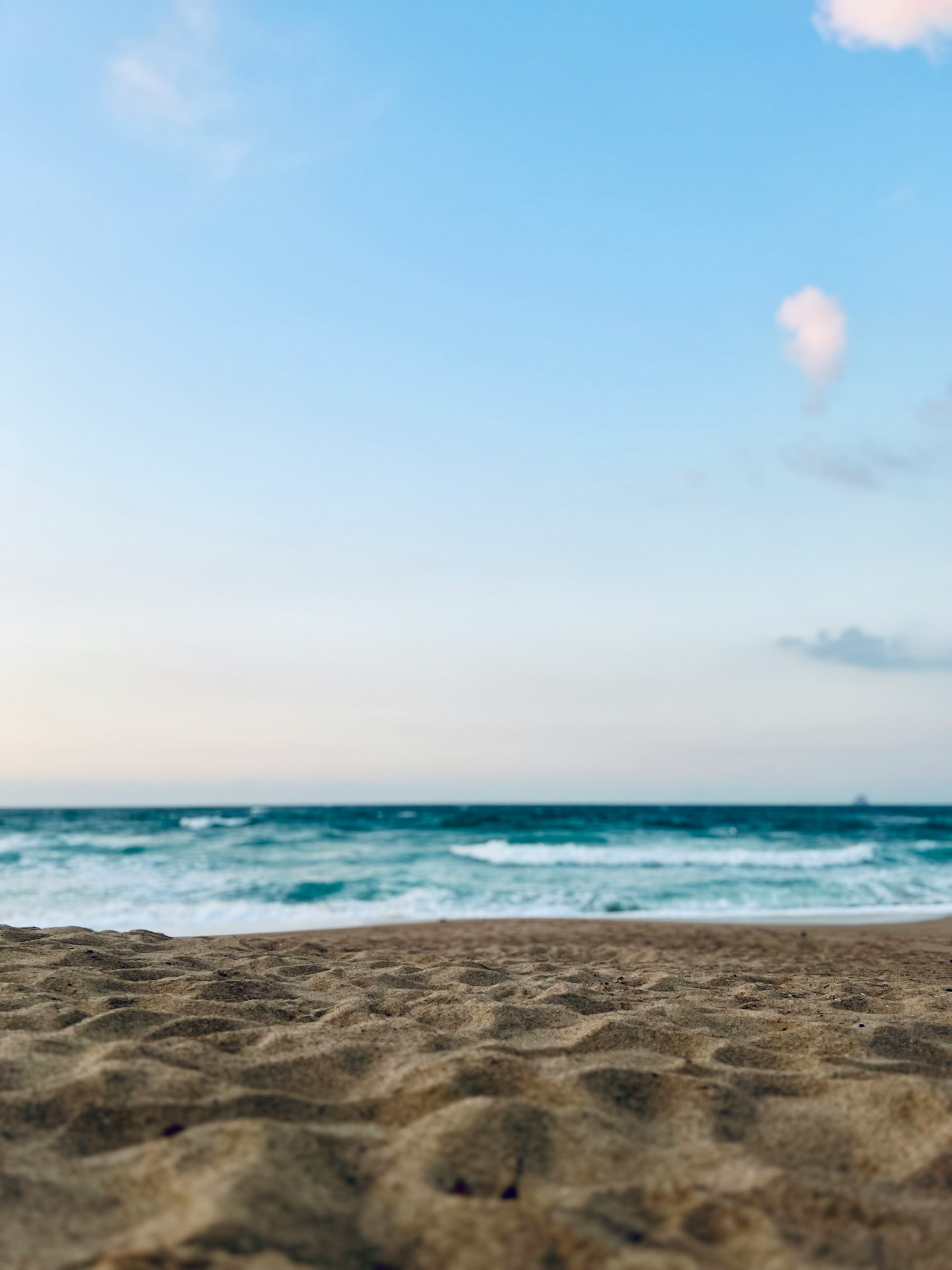 Scène de plage avec du sable et des vagues océaniques sous un ciel bleu