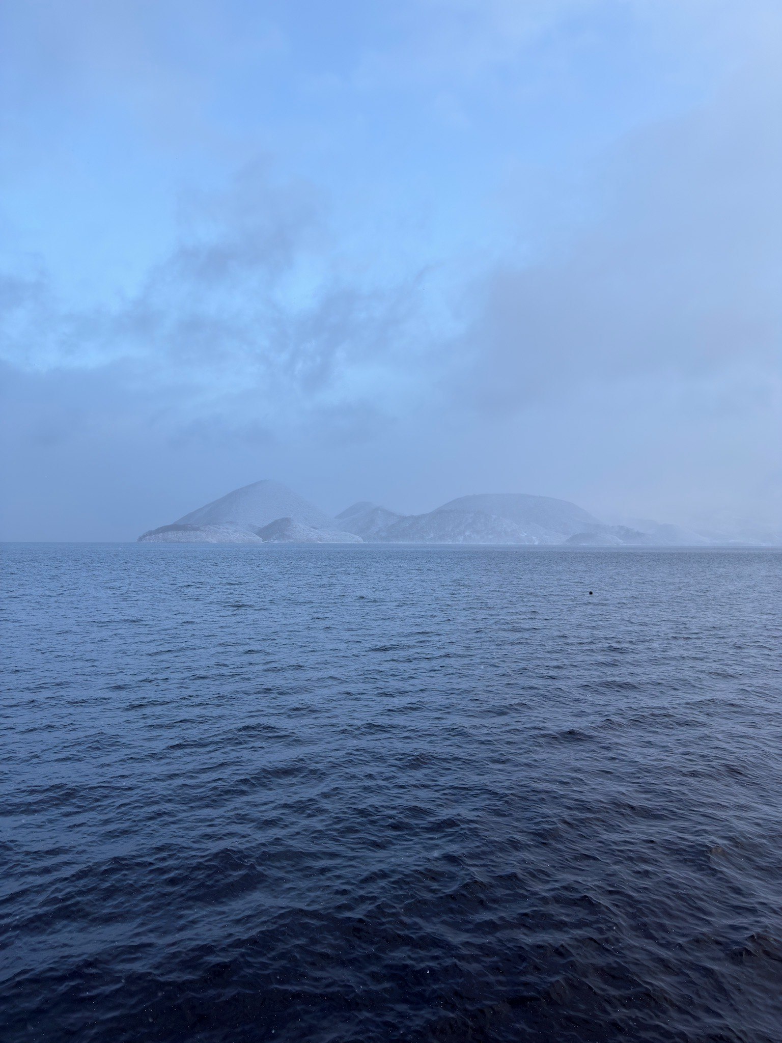 霧に包まれた島々と穏やかな海の風景