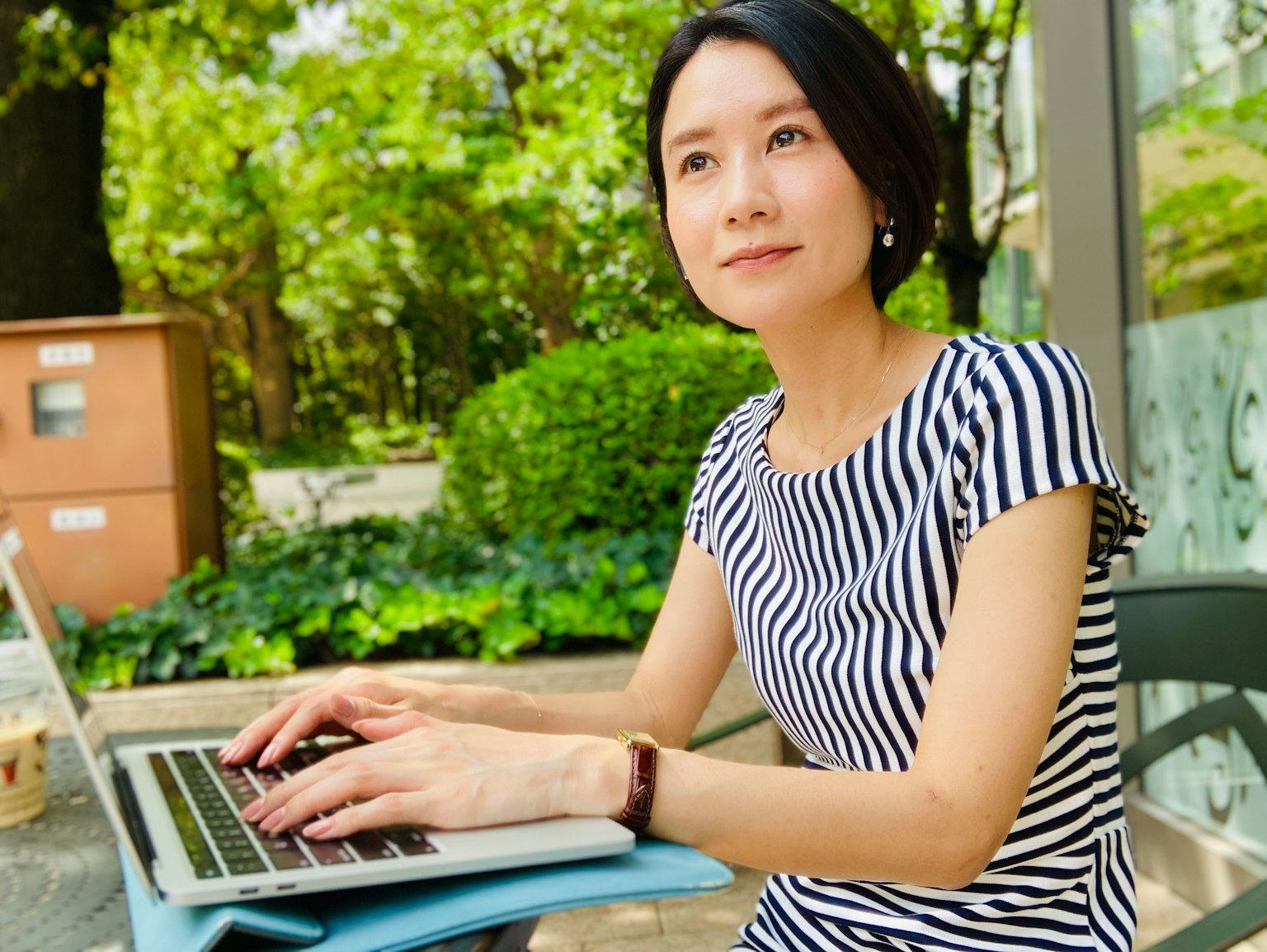 Eine Frau, die in einem Parkcafé einen Laptop benutzt