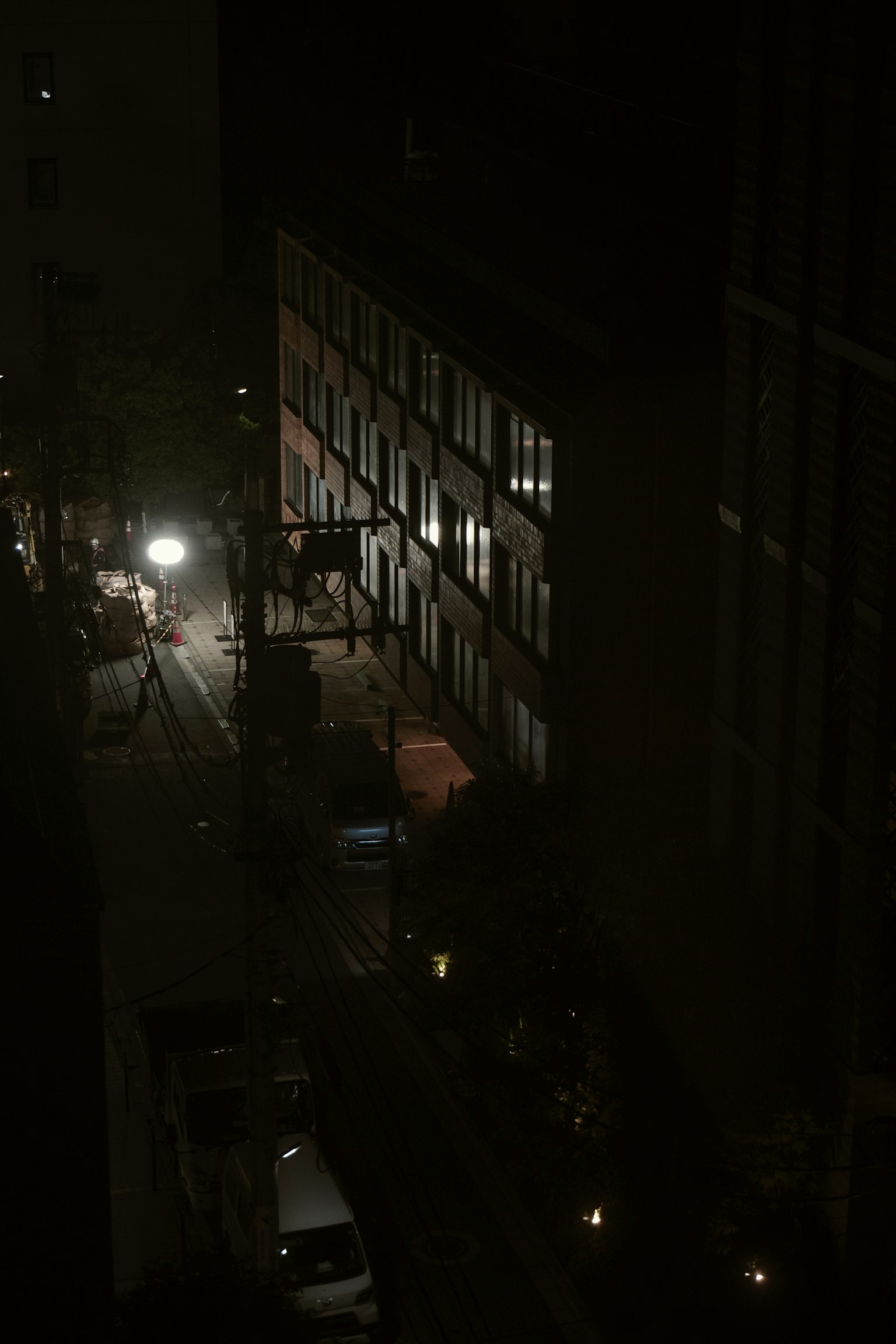 Exterior de un edificio en una calle oscura con iluminación de farolas