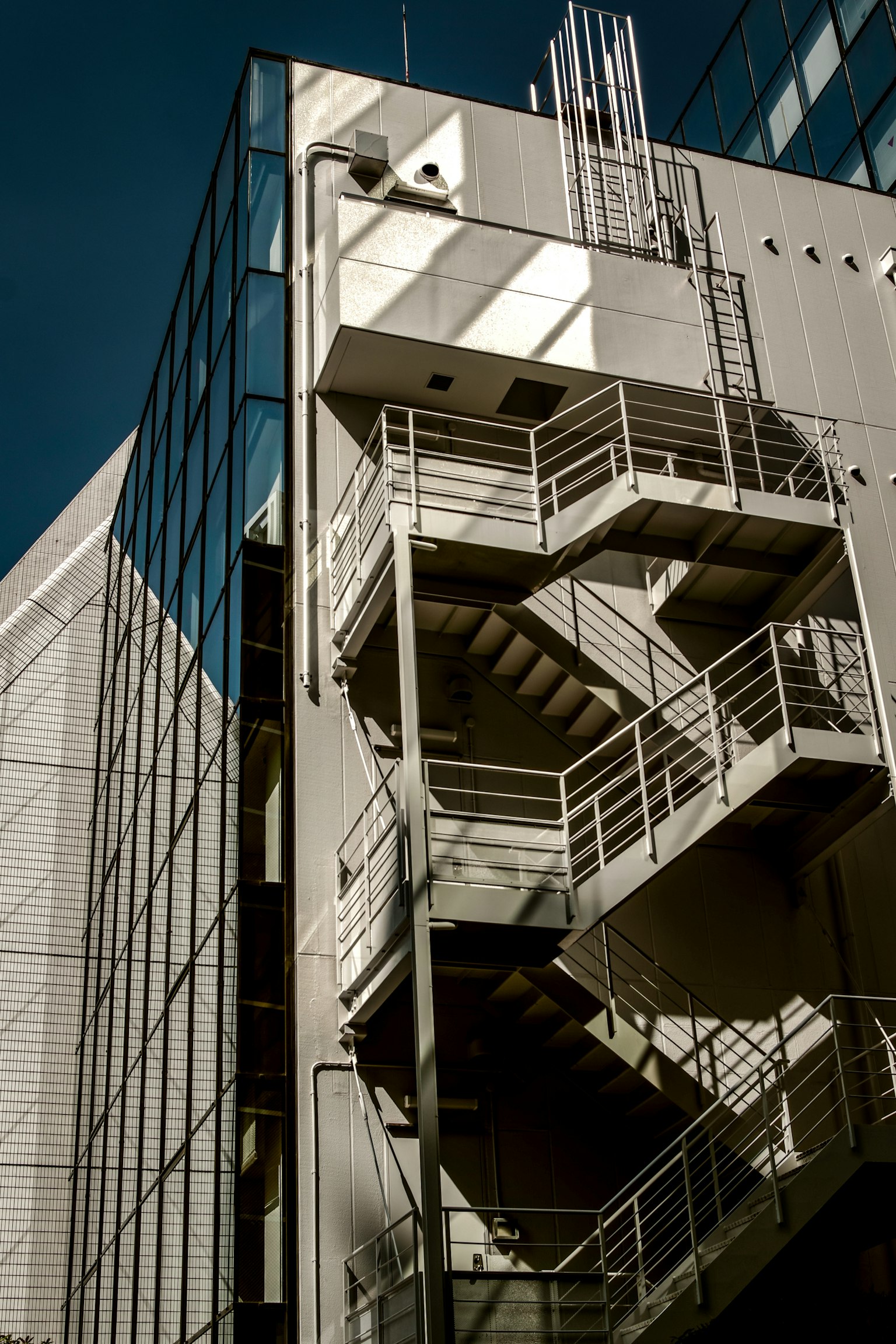 Metalltreppe an der Außenseite eines modernen Gebäudes mit Glasfassade