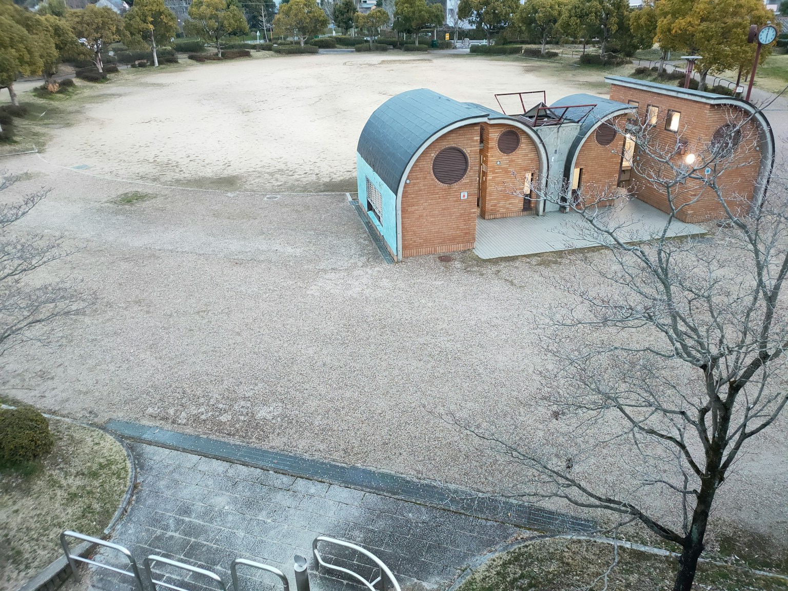 Un parc spacieux avec deux bâtiments en forme d'arc et un sol sec
