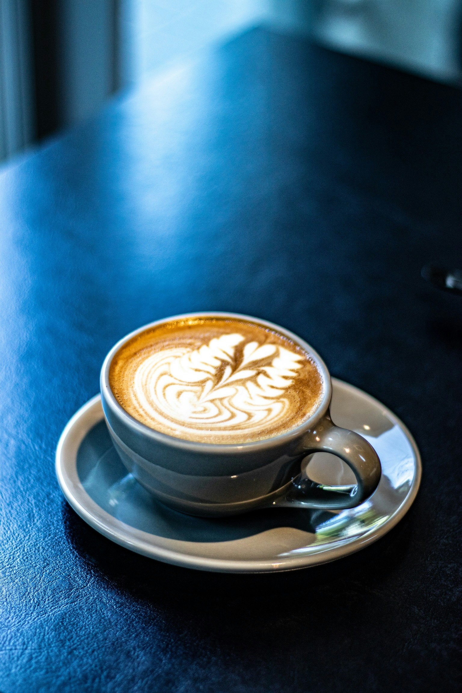 A beautifully crafted latte art in a coffee cup on a black table