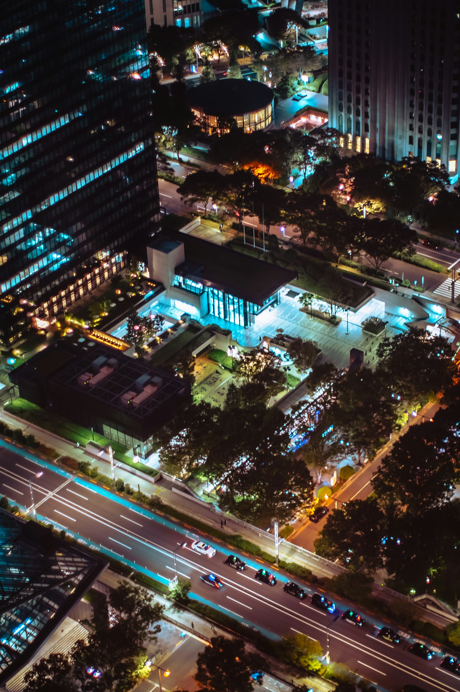Paisaje urbano nocturno con rascacielos y un parque verde