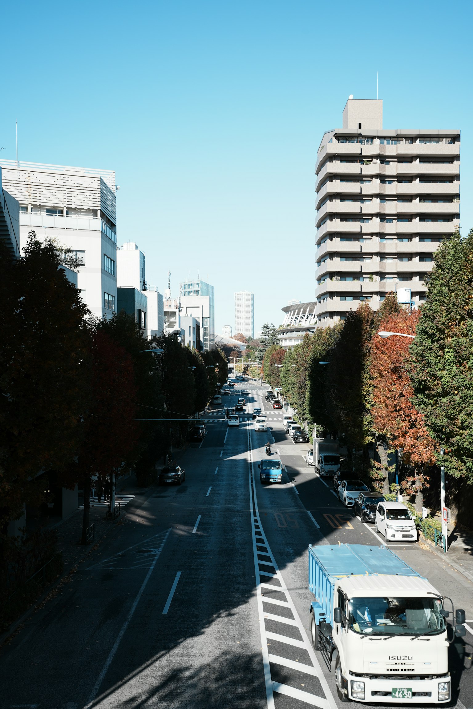 Scène urbaine avec une rue et des bâtiments sous un ciel bleu clair