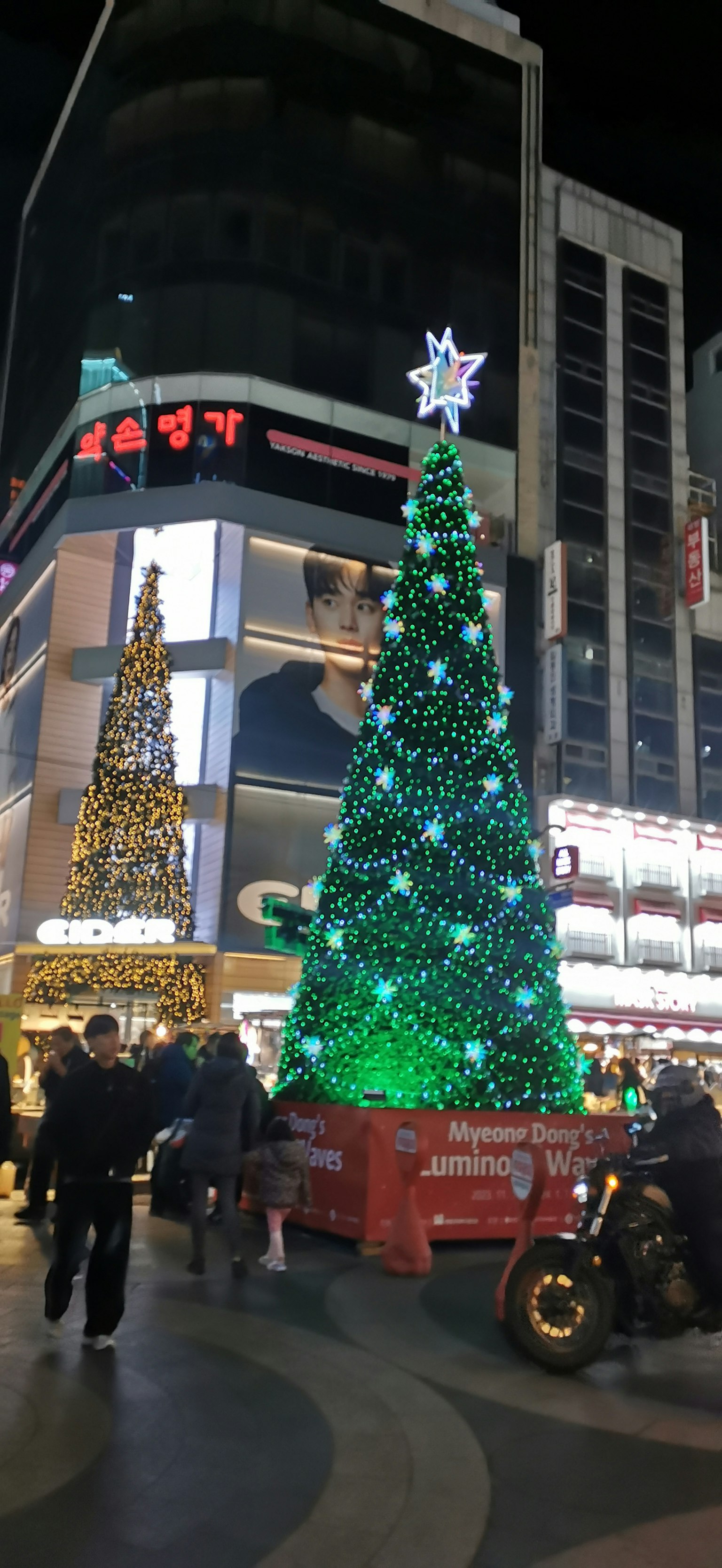 Árbol de Navidad iluminado en una ciudad bulliciosa por la noche