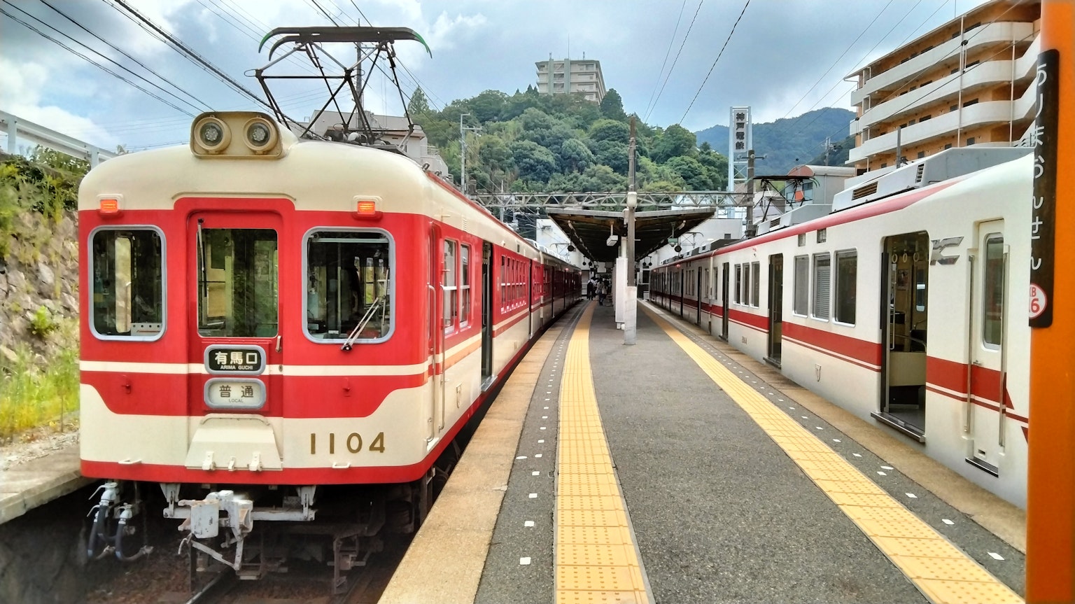 รถไฟสีแดงที่สถานีกับภูเขาเป็นพื้นหลัง