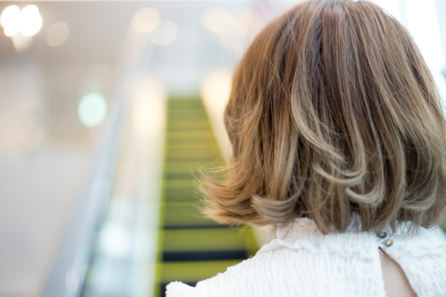 Imagen de una mujer vista desde atrás con escaleras verdes