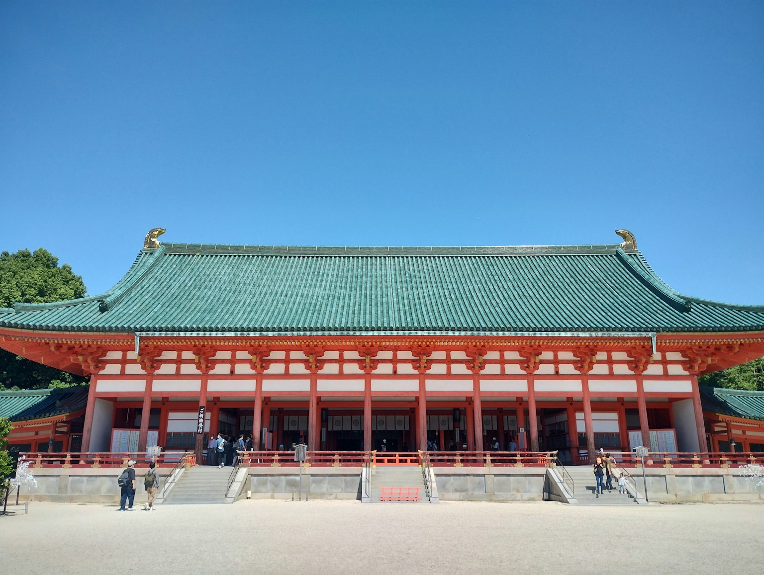 Traditionelles japanisches Gebäude mit grünem Dach und roten Säulen in einem offenen Raum