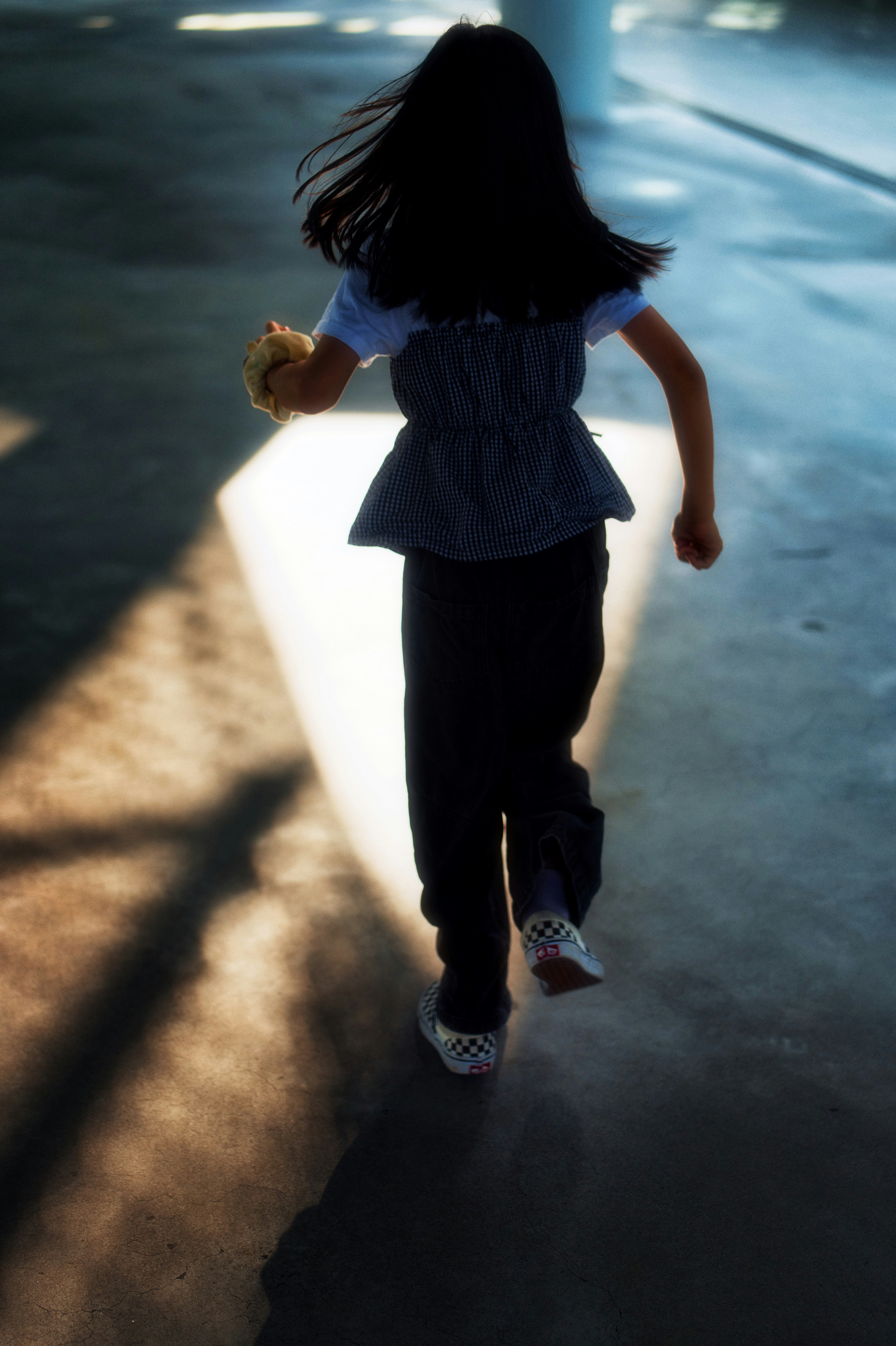 夜の屋外で走る子どもの後ろ姿