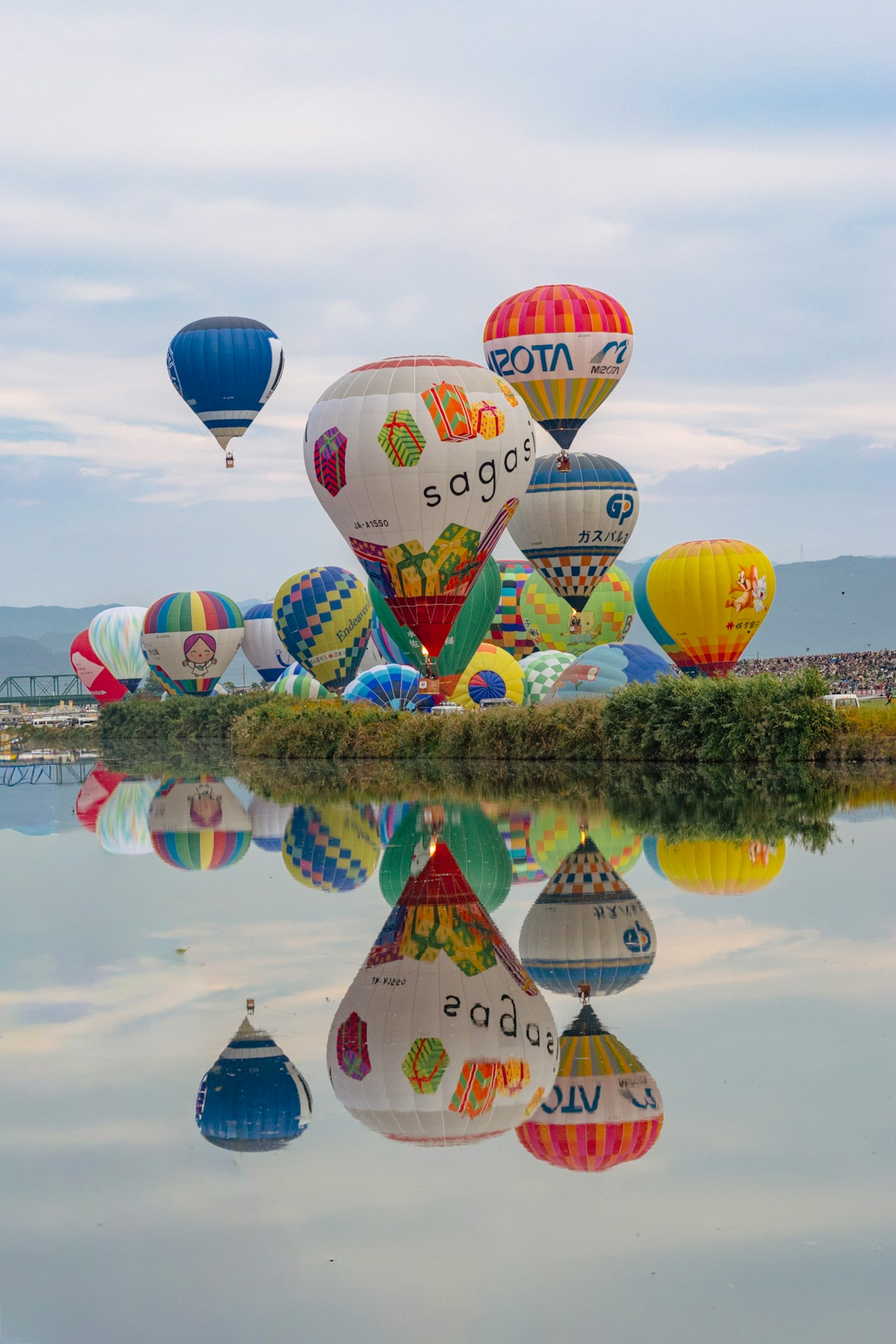 カラフルな熱気球が水面に映る風景