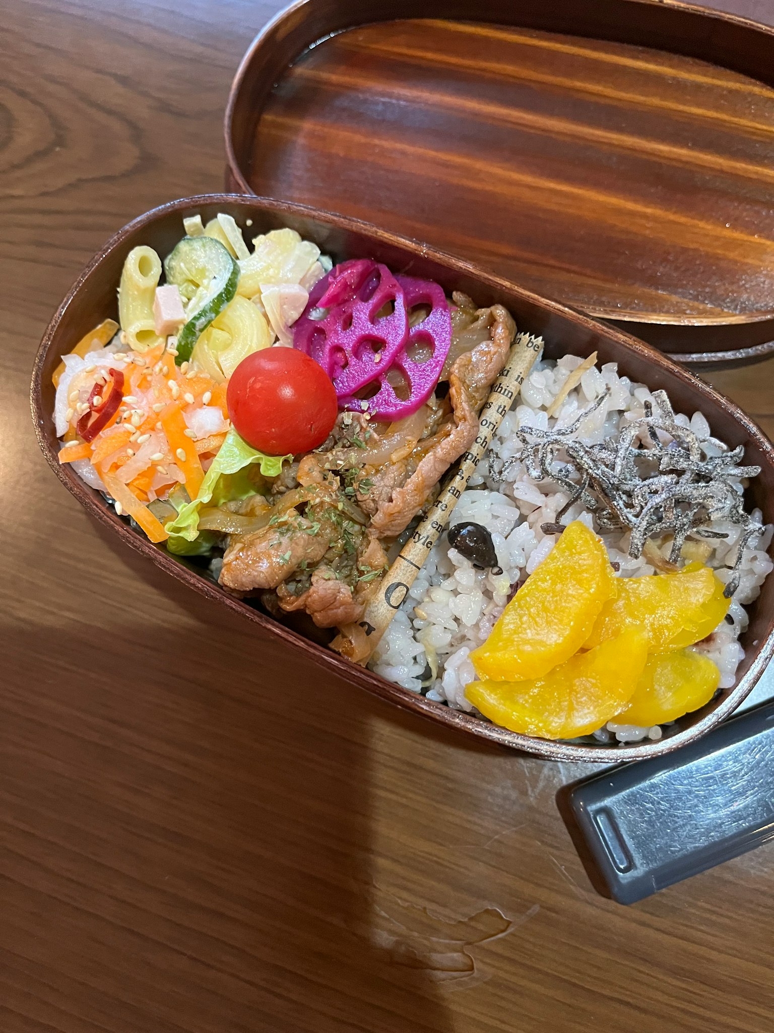 Hộp bento bằng gỗ đầy cơm gà, salad và nhiều loại trái cây