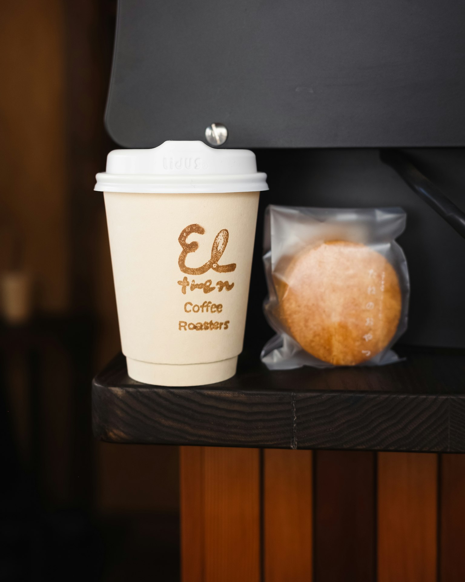 Coffee cup and cookie displayed on a wooden table