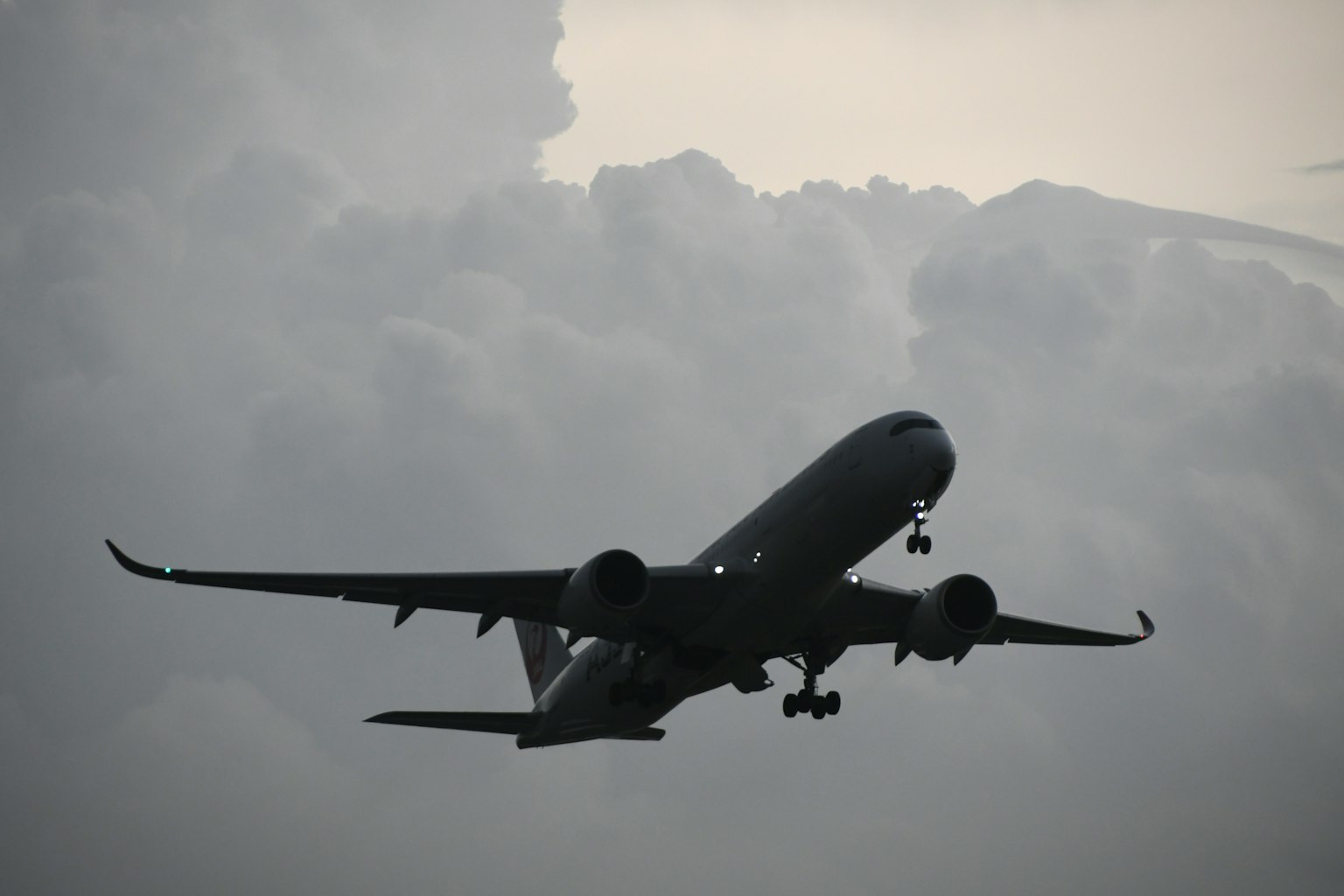 Silhouette di un aereo che vola tra le nuvole