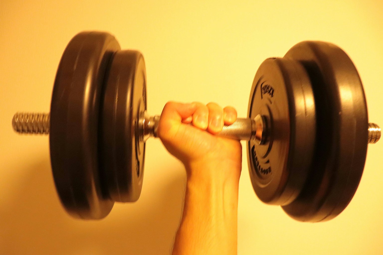 Imagen de una mano sosteniendo un dumbbell negro