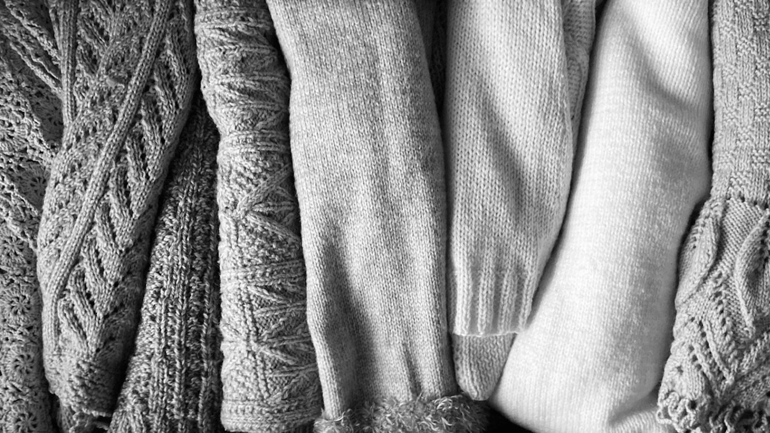 Eine monochrome Anordnung verschiedener strukturierter Pullover