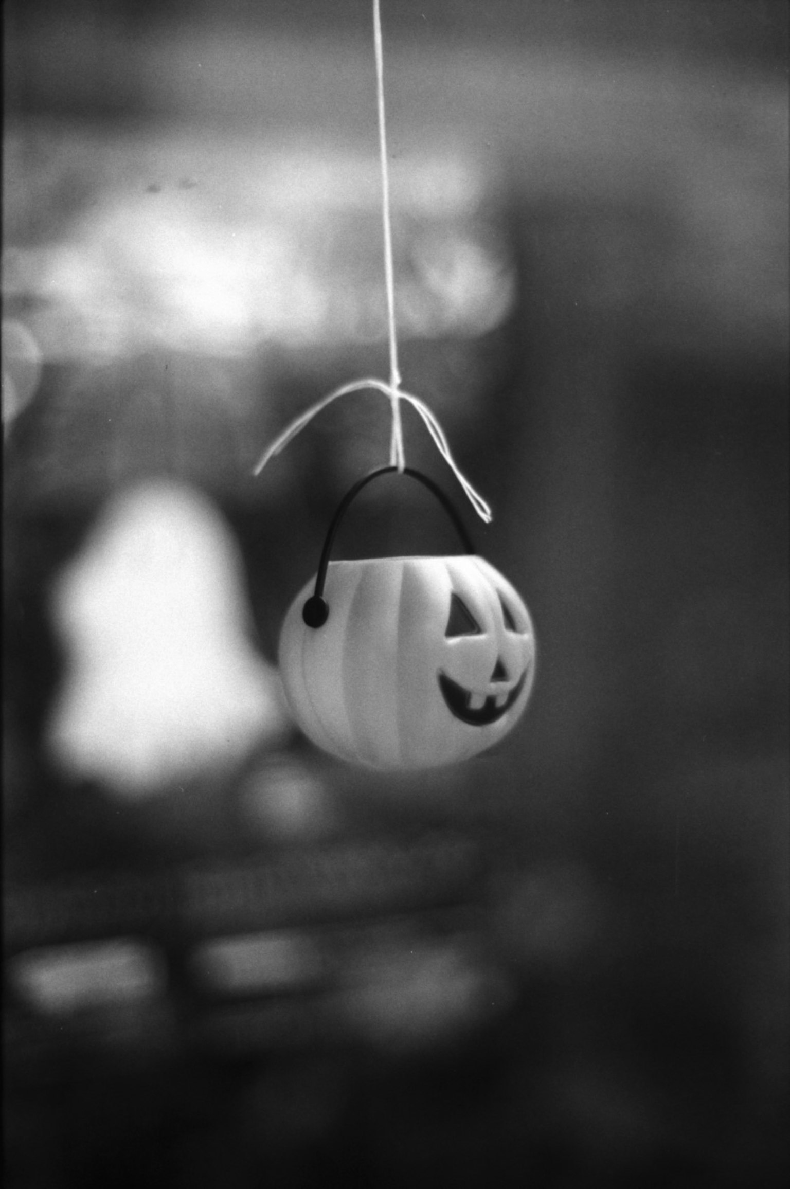 White Halloween pumpkin decoration hanging in monochrome image