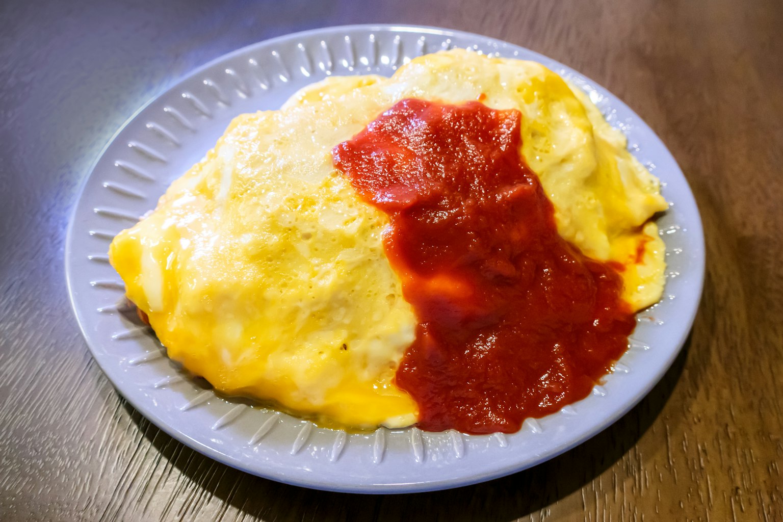 Omelett-Reis auf einem Teller mit Ketchup serviert