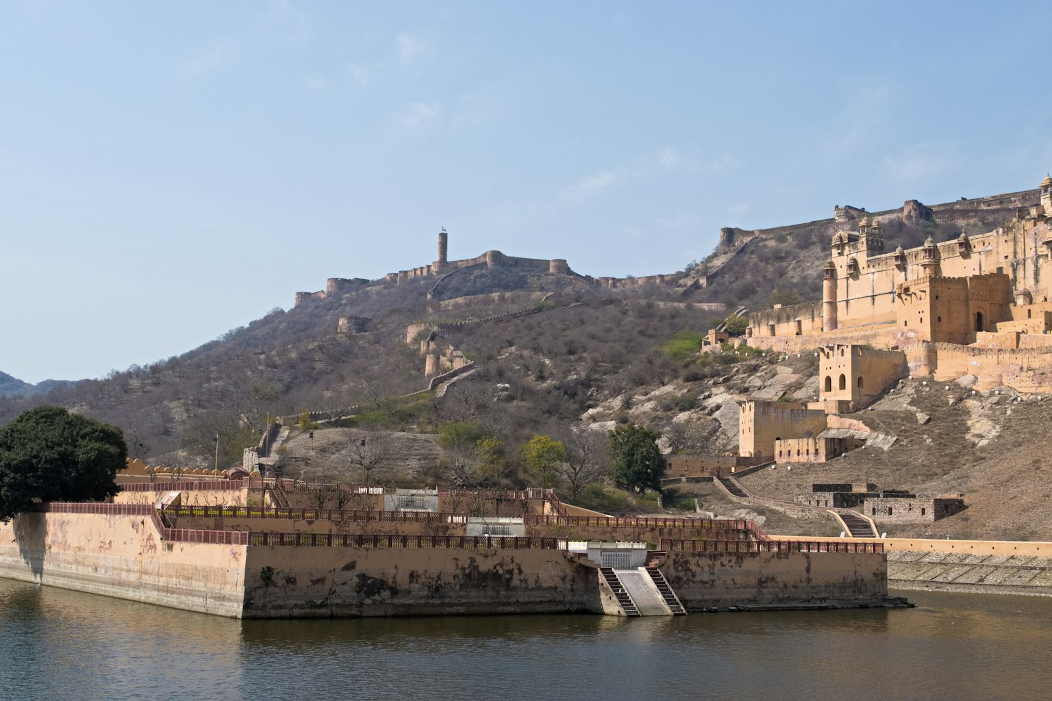 Blick auf das Amber Fort mit den umliegenden Hügeln und dem See