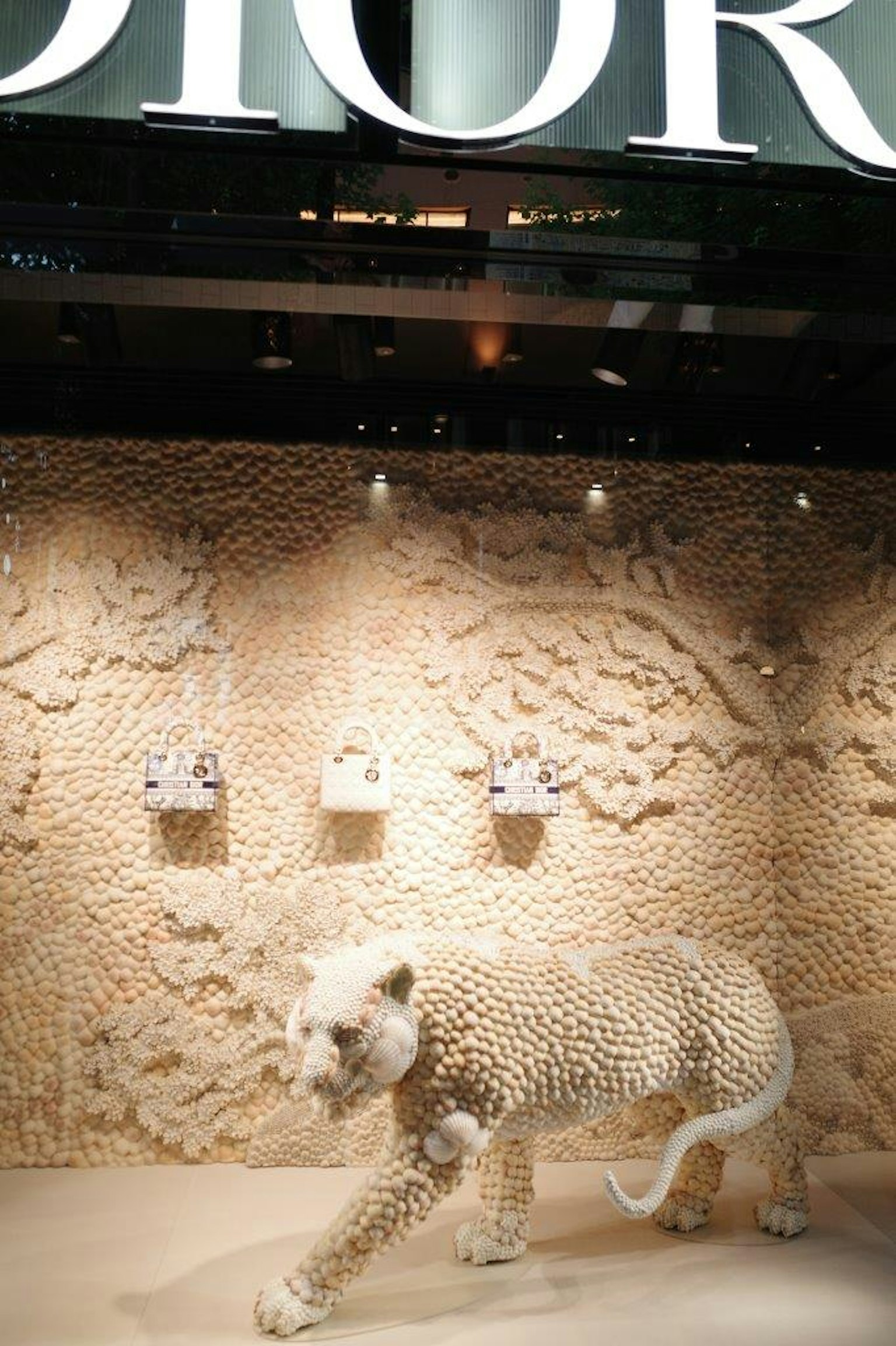 Escultura de leopardo blanco en la vitrina de Dior con bolsos