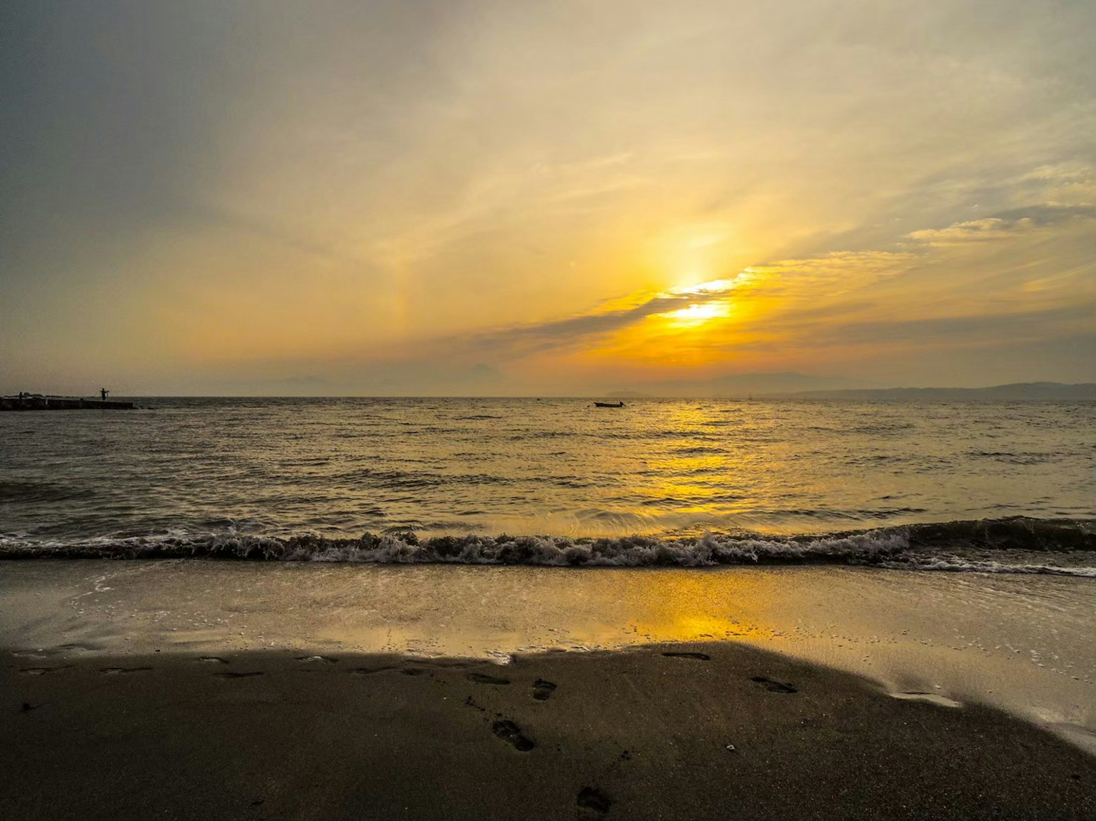 海上日落，海滩上的温和波浪
