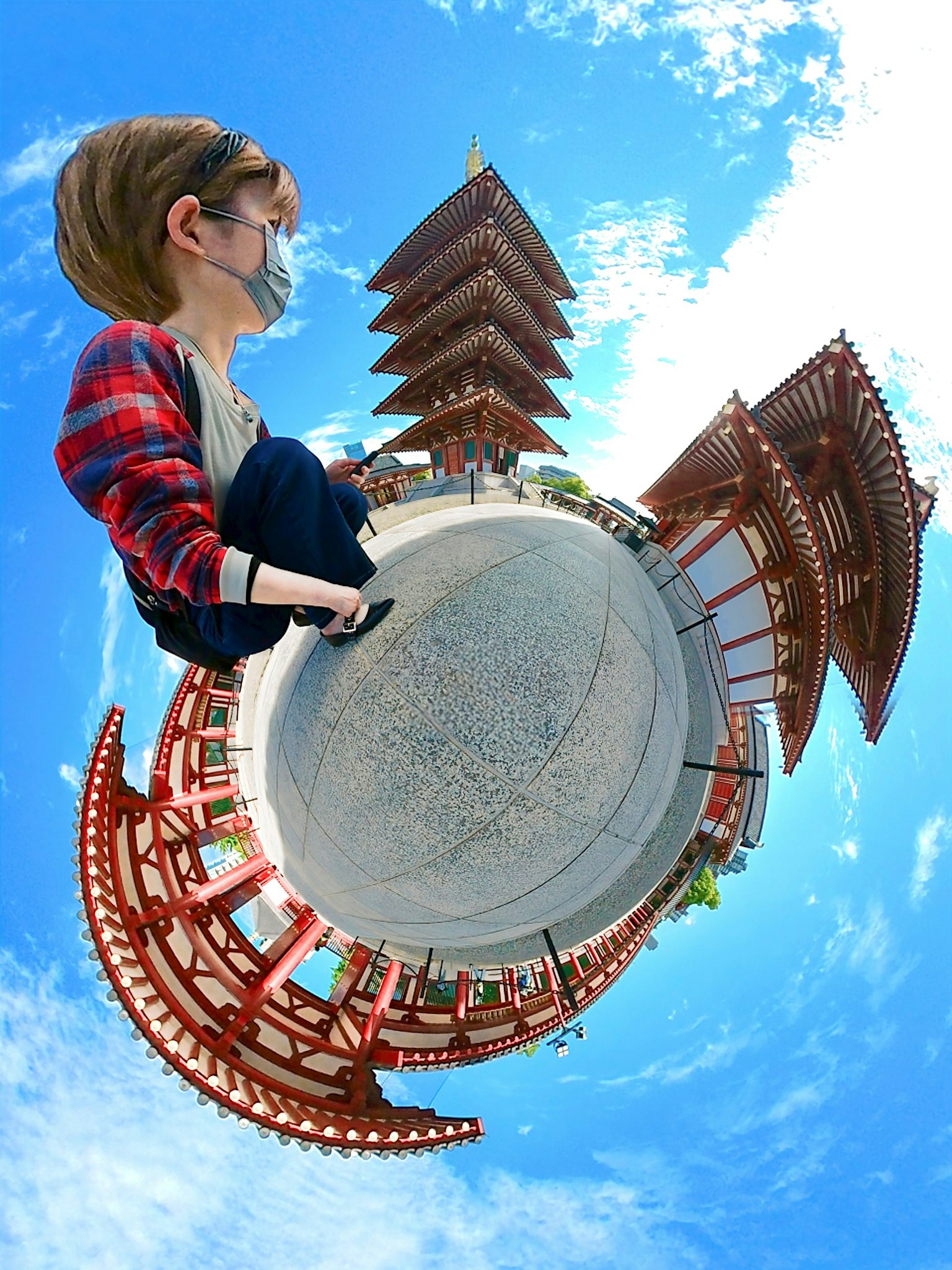 Image panoramique présentant des bâtiments traditionnels et une personne sous un ciel bleu