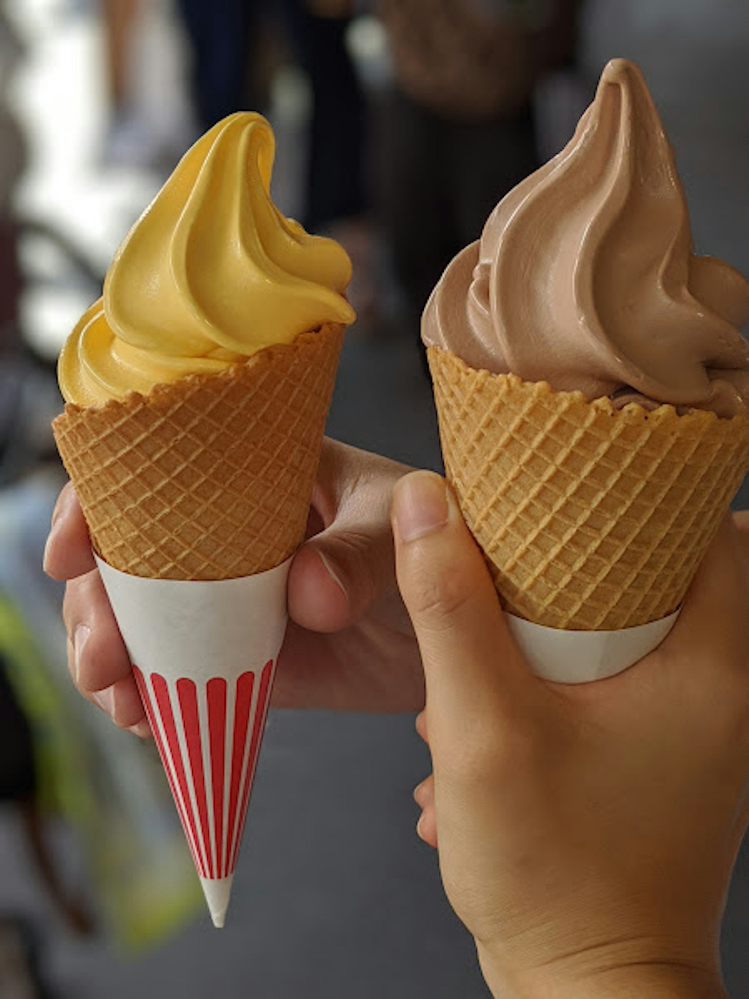 Dua cone es krim di tangan satu vanila dan satu coklat