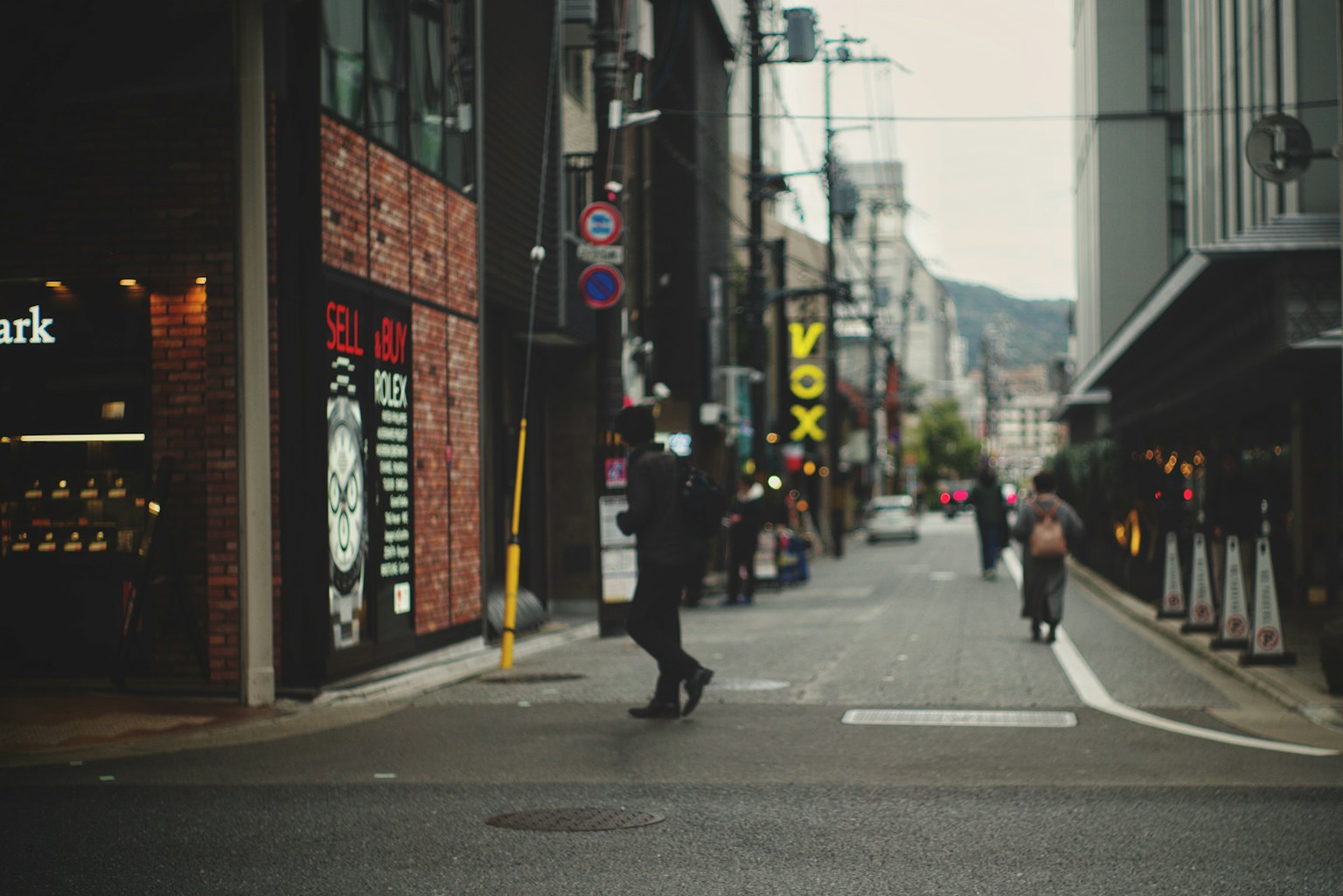 Urban scene with people walking on the street shop signs visible