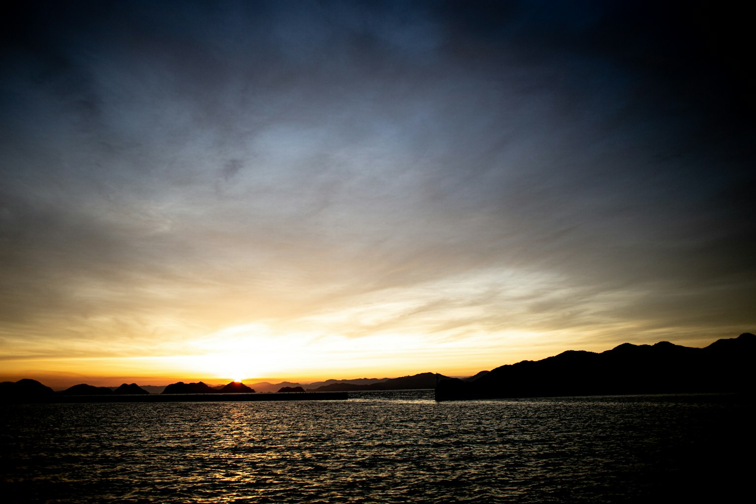 海上日落的风景，山脉呈现出轮廓