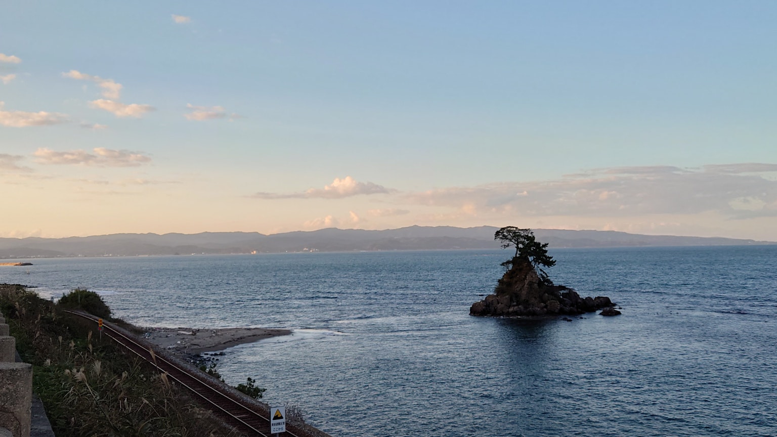 Una pequeña isla en el océano con un árbol solitario y aguas tranquilas