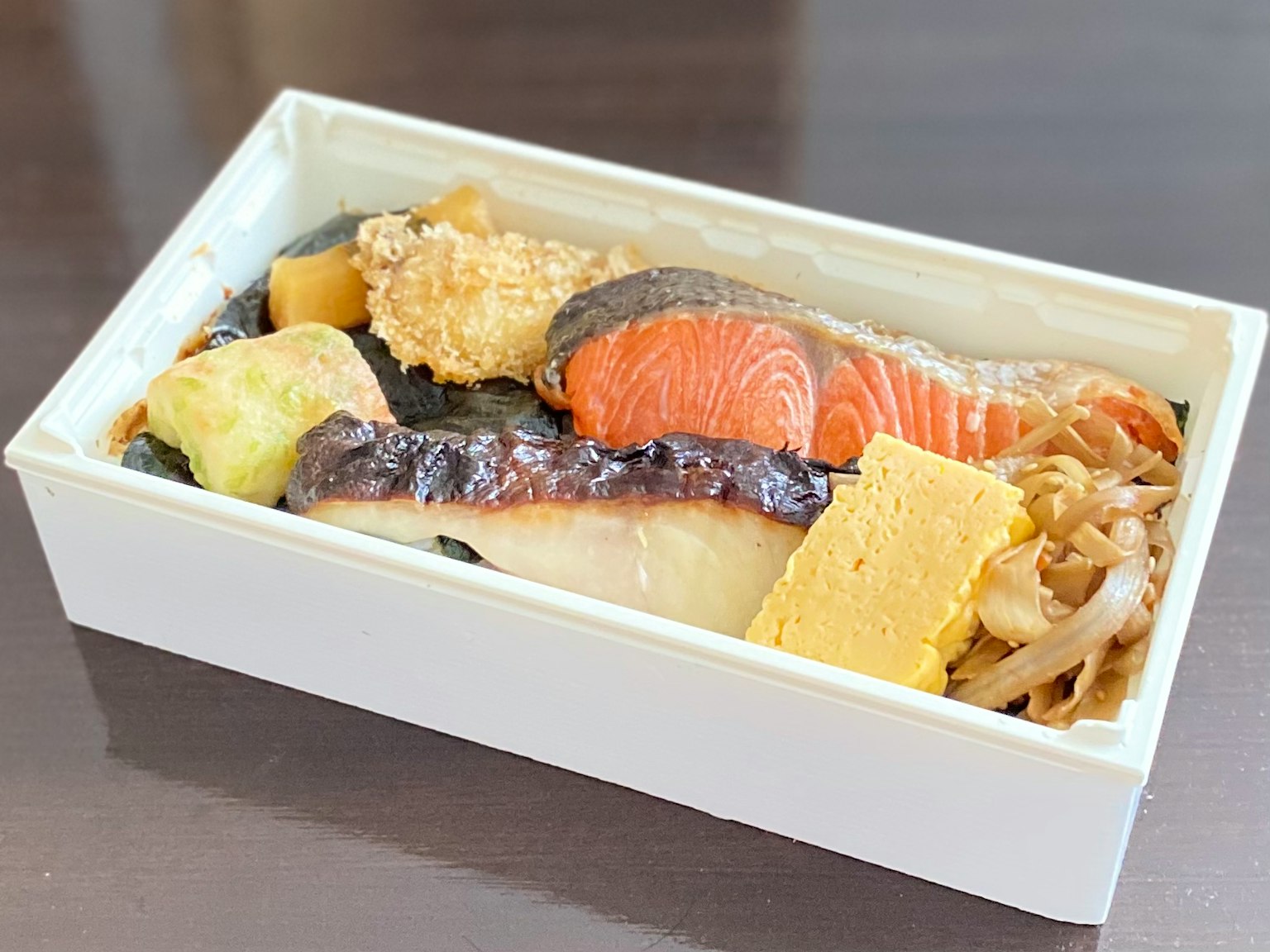 Món sushi và cá nhiều loại trong hộp bento trắng