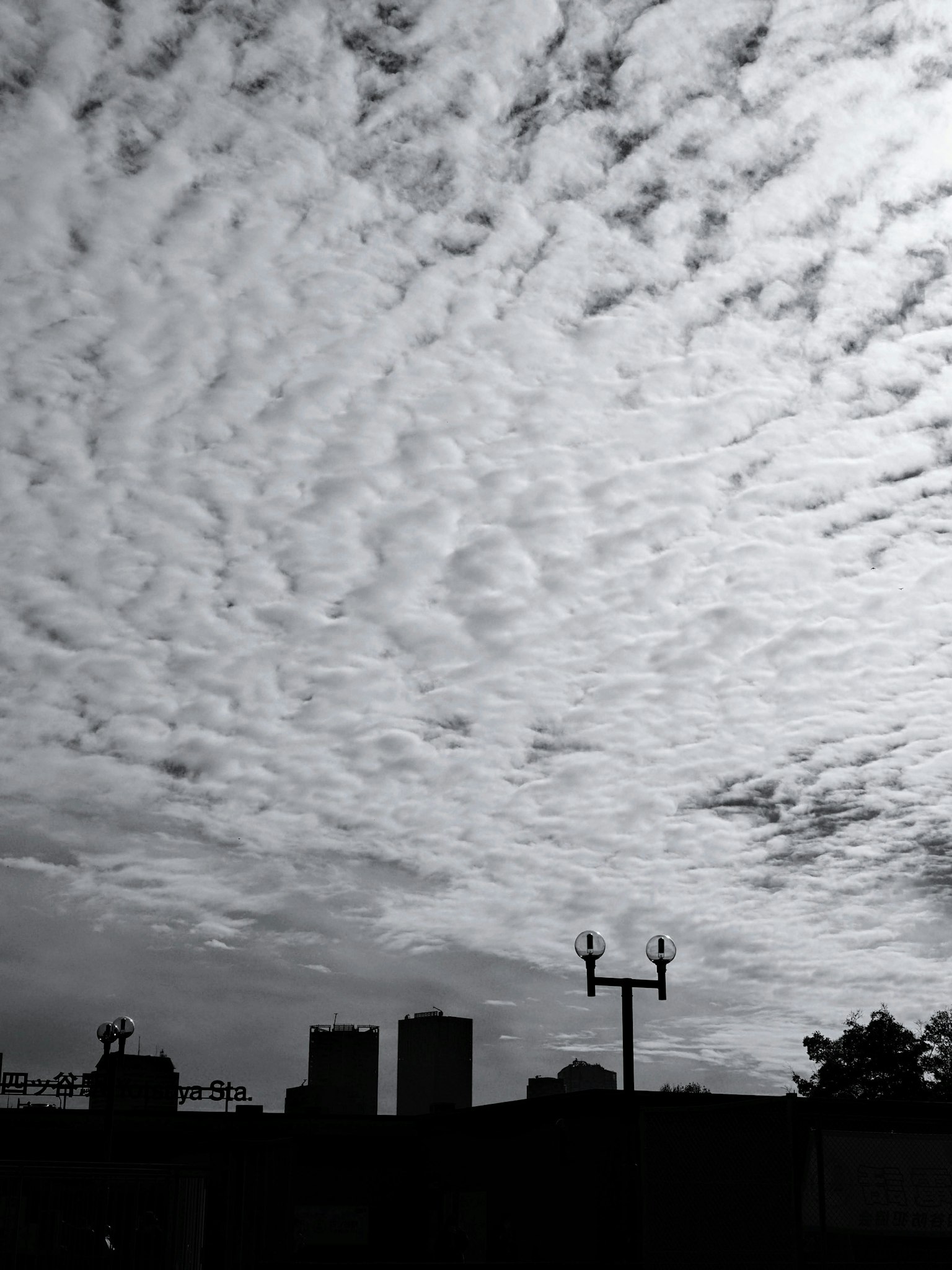Schwarze und weiße Wolken breiten sich über den Himmel mit silhouettierten Gebäuden