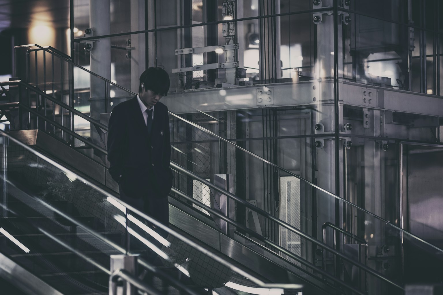 一名身着西装的男子在昏暗的灯光下走下楼梯