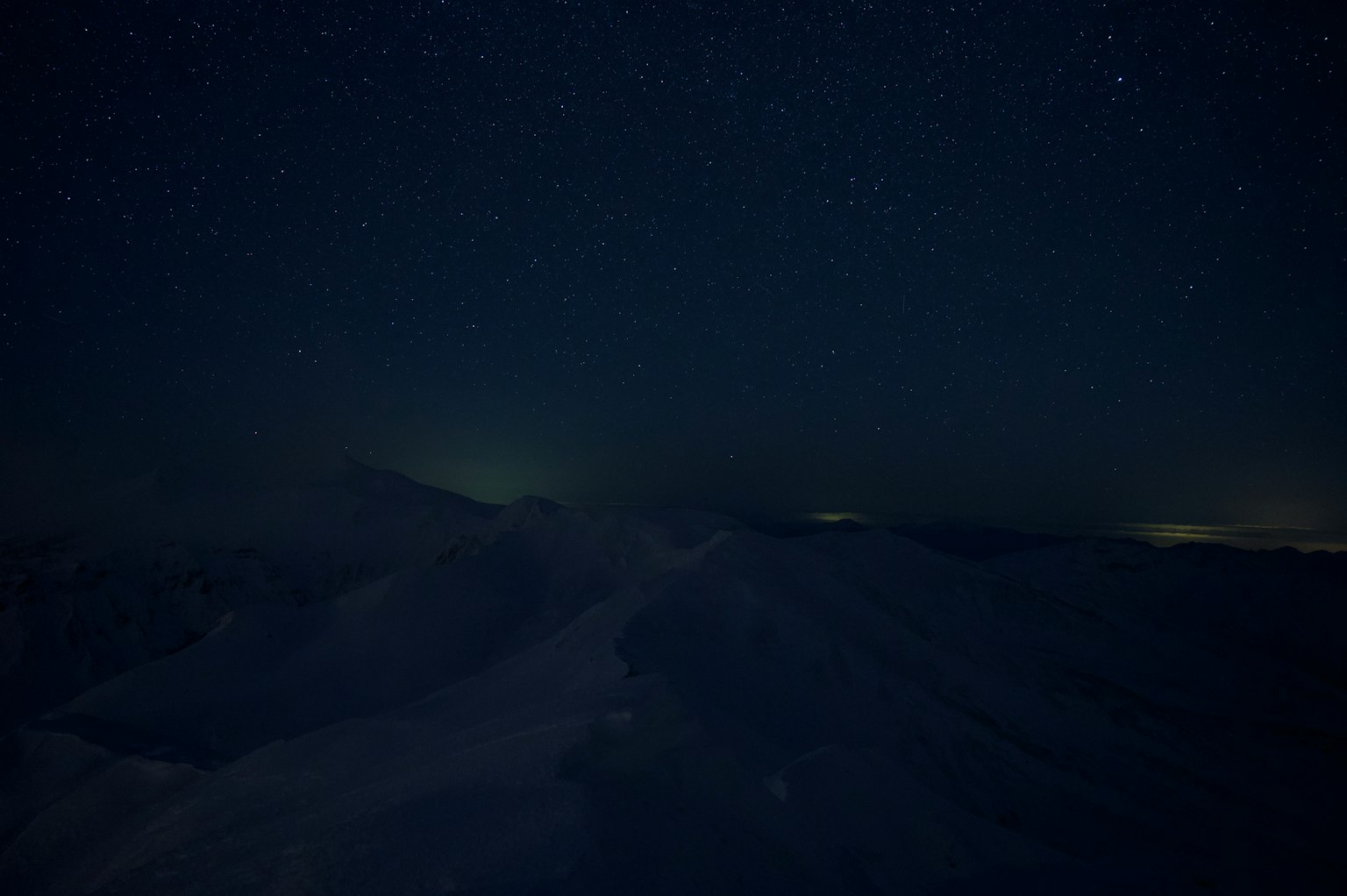 夜空中的星星與黑暗的山脊輪廓